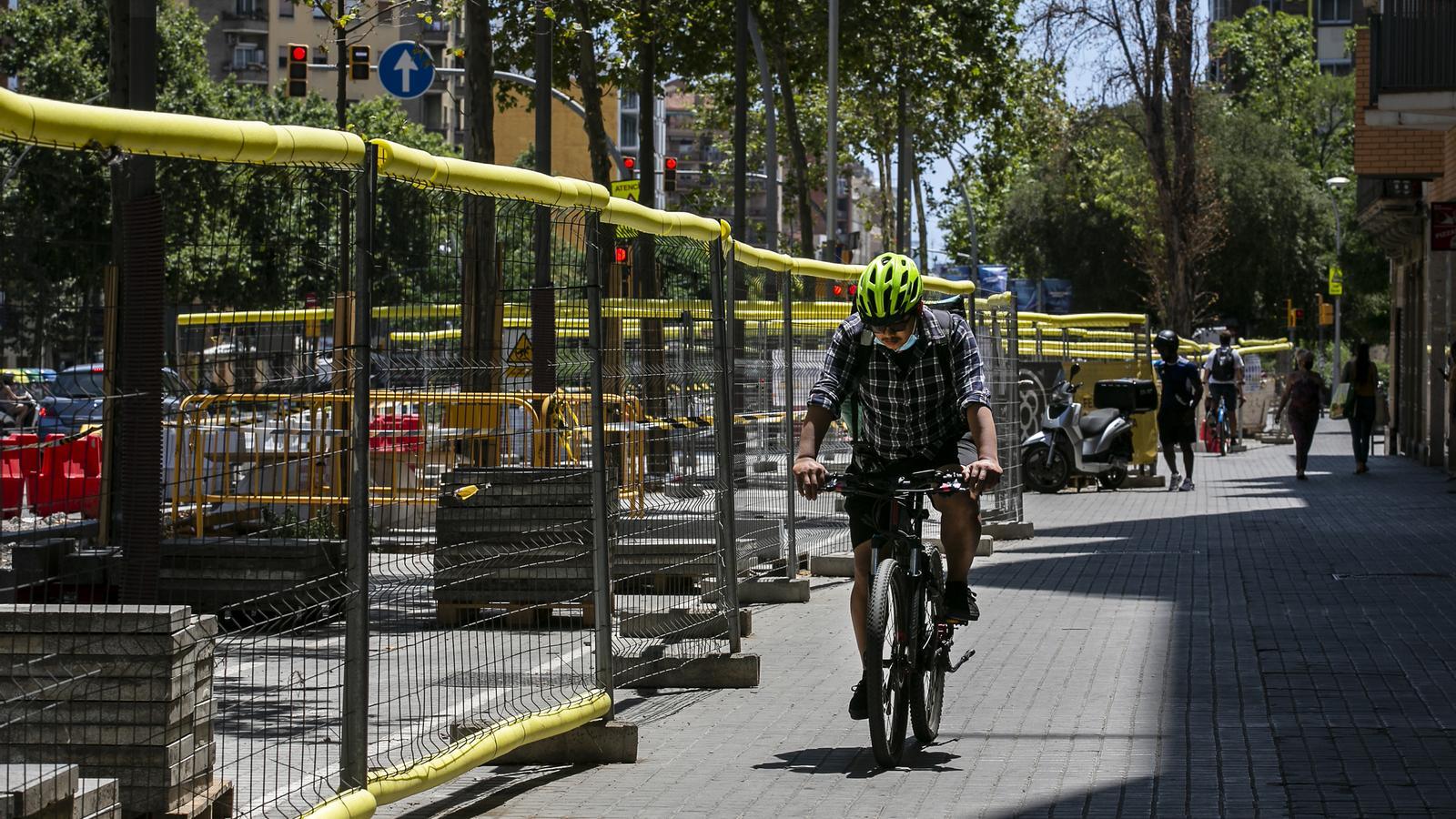 Un ciclista pasa por delante de un espacio en obras en la avenida Meridiana.