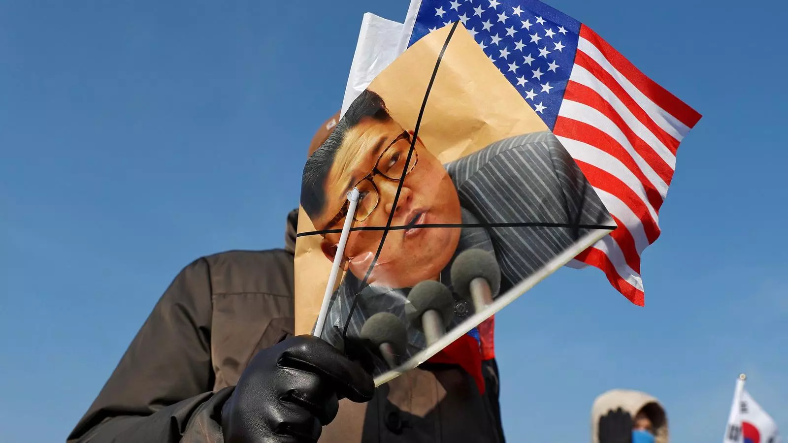 Manifestants contraris a Corea del Nord protesten amb banderes dels Estats Units i retrats tatxats de Kim Jong Un abans de la cerimònia d'inauguració dels Jocs