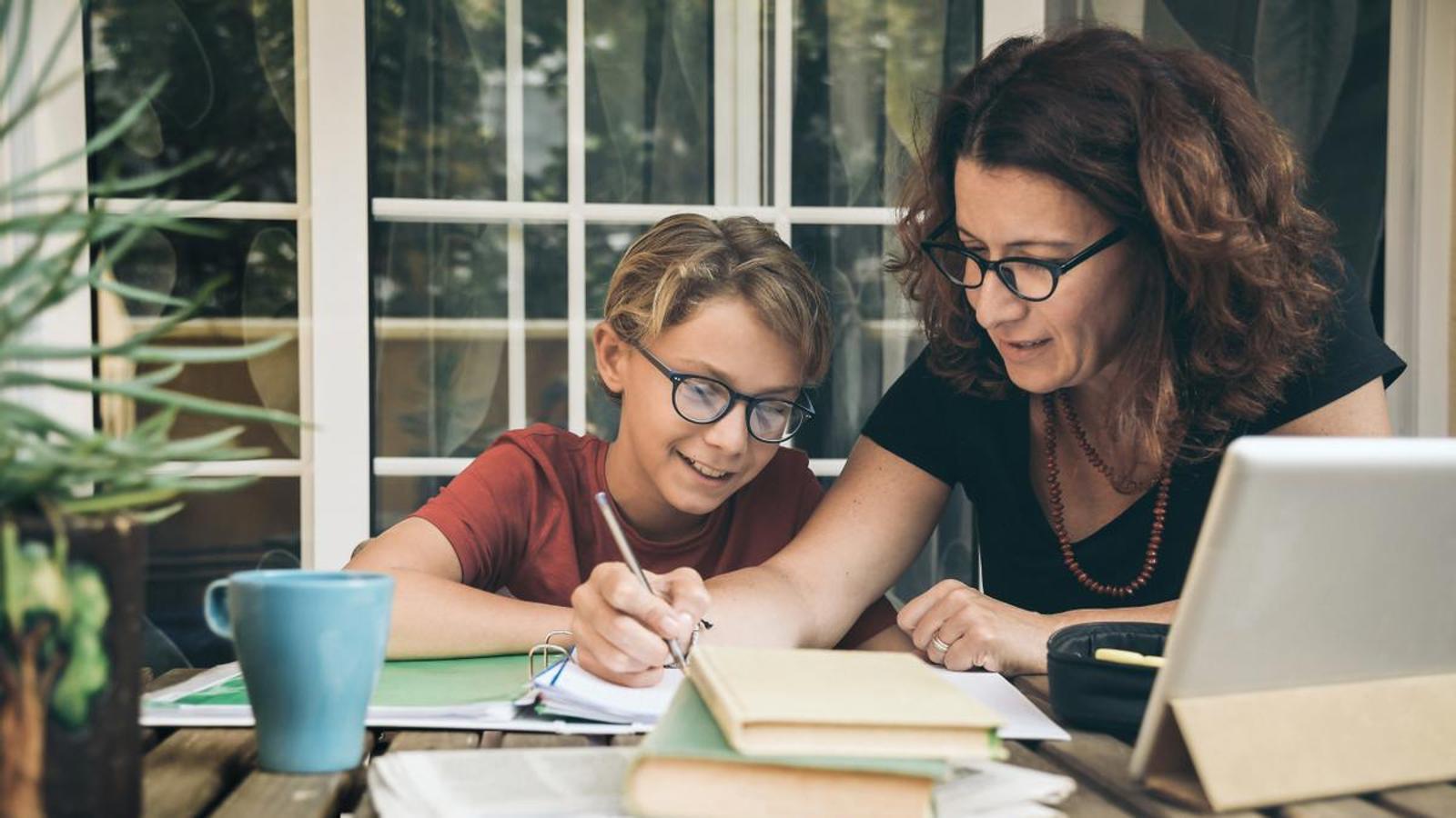 Un niño estudia con ayuda de una profesora