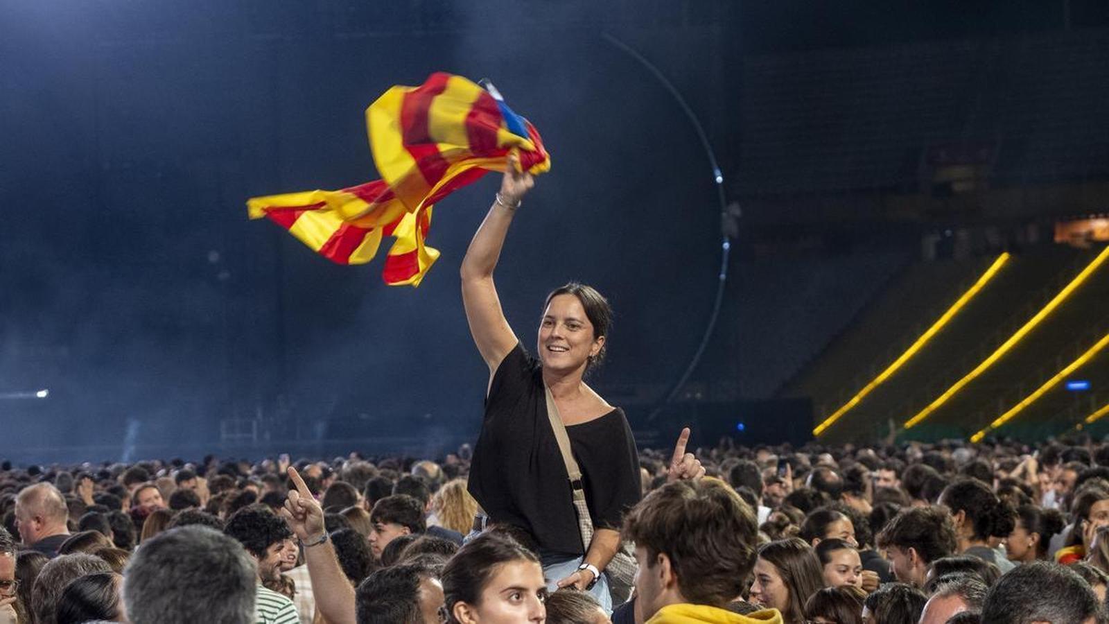 Una mujer ondeando una estelada entre el público de uno de los conciertos de Oques Grasses en el Estadio Olímpico Lluís Companys.