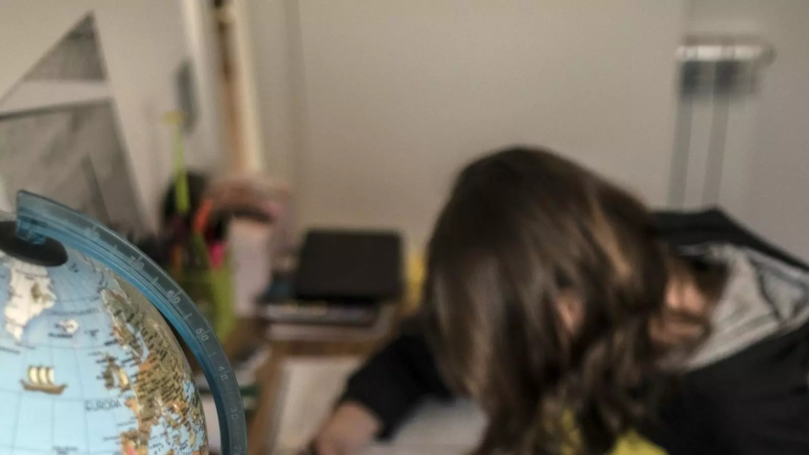 Una nena fa treballs a casa després que s'hagin suspès les classes a les escoles.