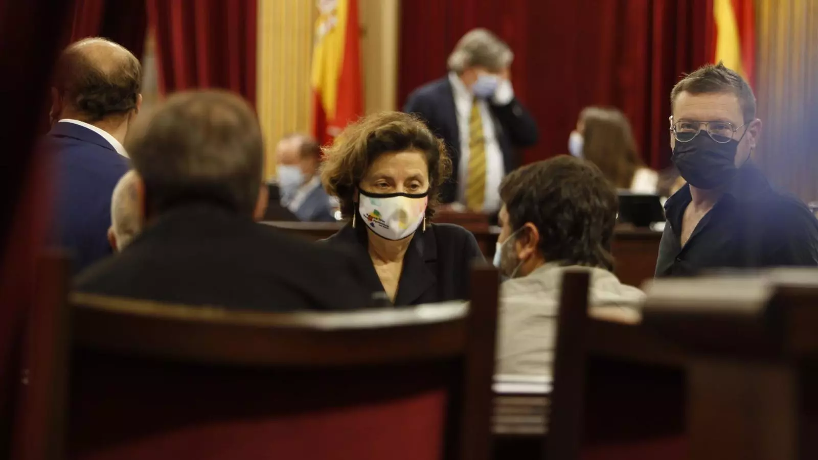 La consellera d'Afers Socials de MÉS per Mallorca, Fina Santiago, xerra amb els seus companys de partit en el Parlament.