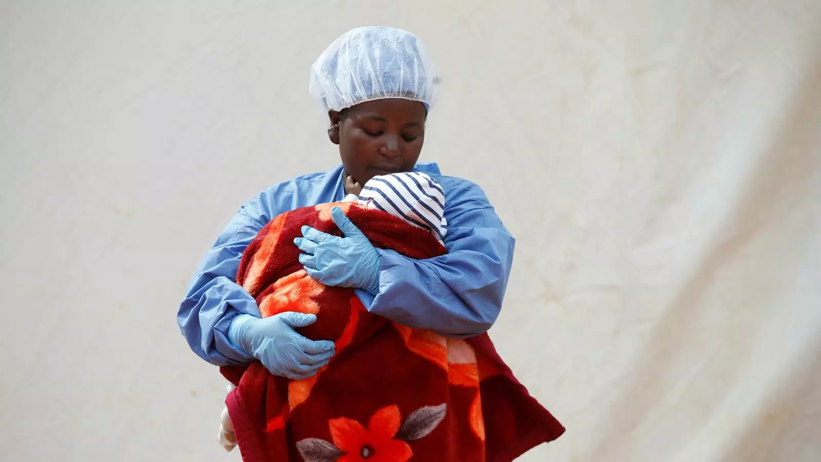 Rachel Kahindo, una supervivent d'ebola que treballa com a cuidadora de nadons que són víctimes confirmades del brot, sosté un infant a l'exterior d'un dels centres de tractament de l'epidèmia a Butembo, al nord-est de la República Democràtica del Congo.