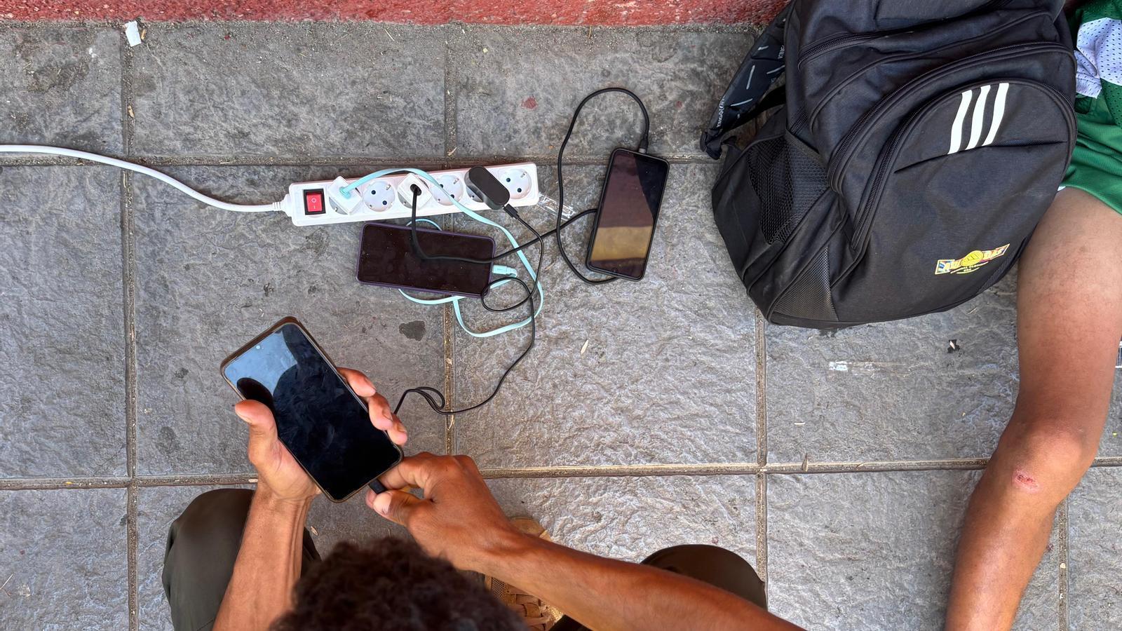 Un joven intenta cargar su teléfono móvil en Ceuta.