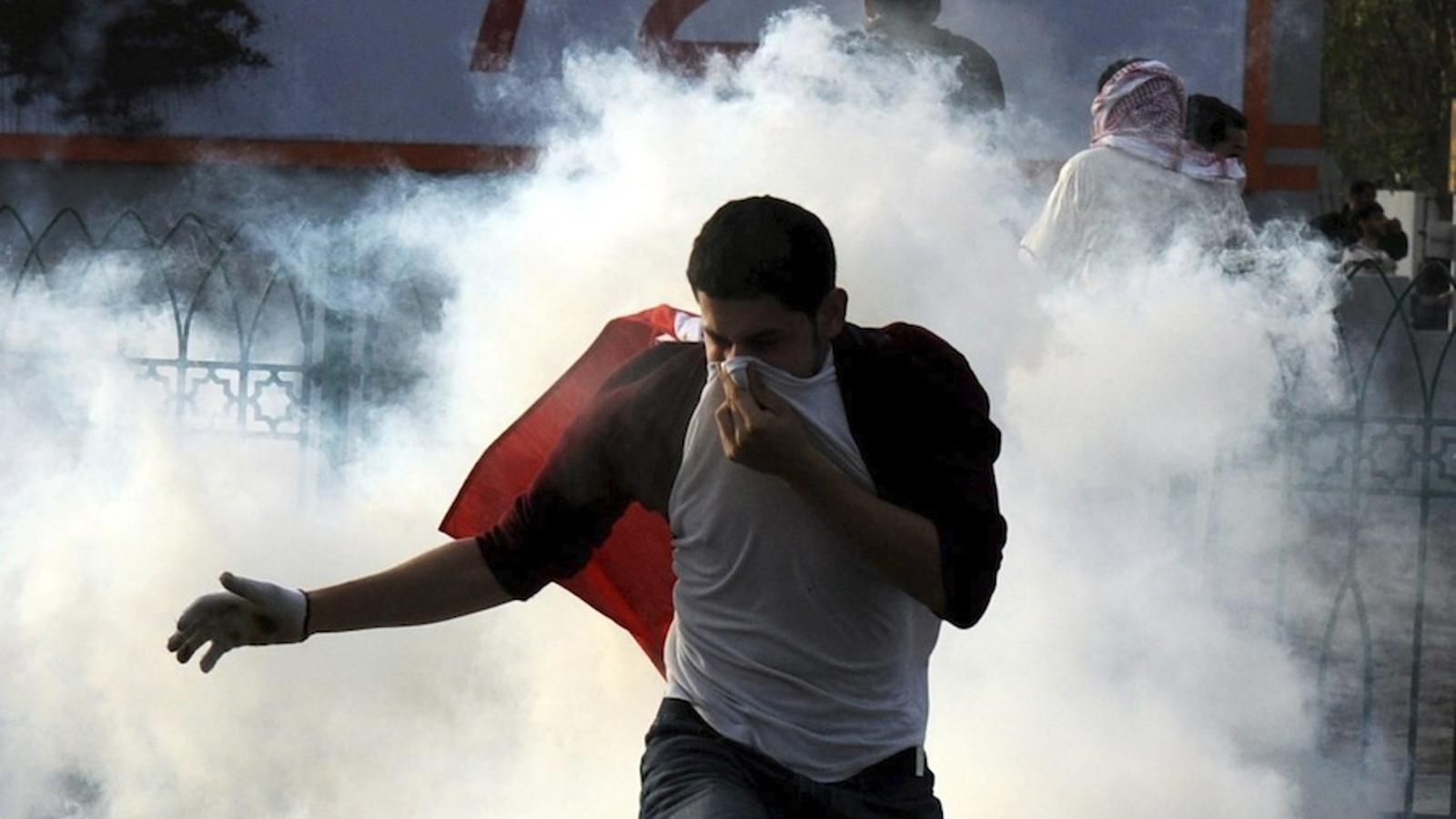 Un manifestant es protegeix dels gasos lacrimògens / EFE