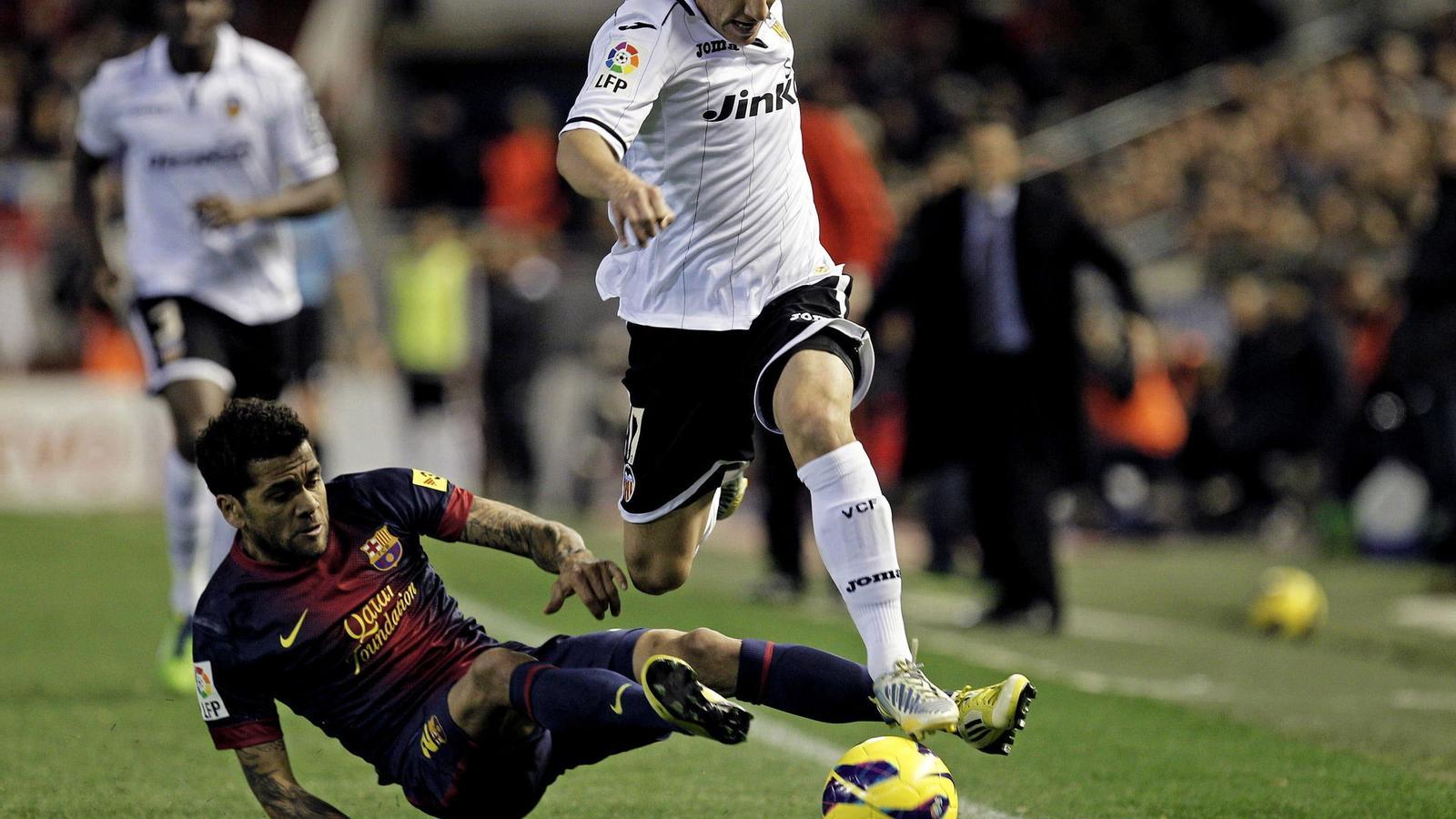 Dani Alves intenta disputar la pilota a Andrés Guardado.