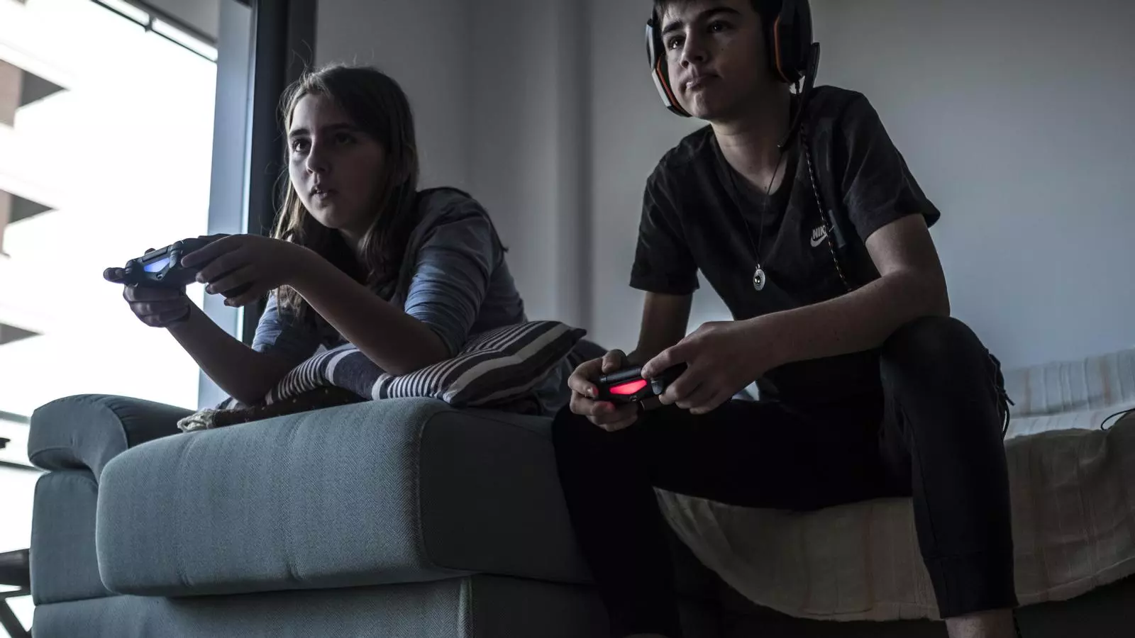 Un nen i una nena jugant a videojocs a una consola, en una imatge d'arxiu