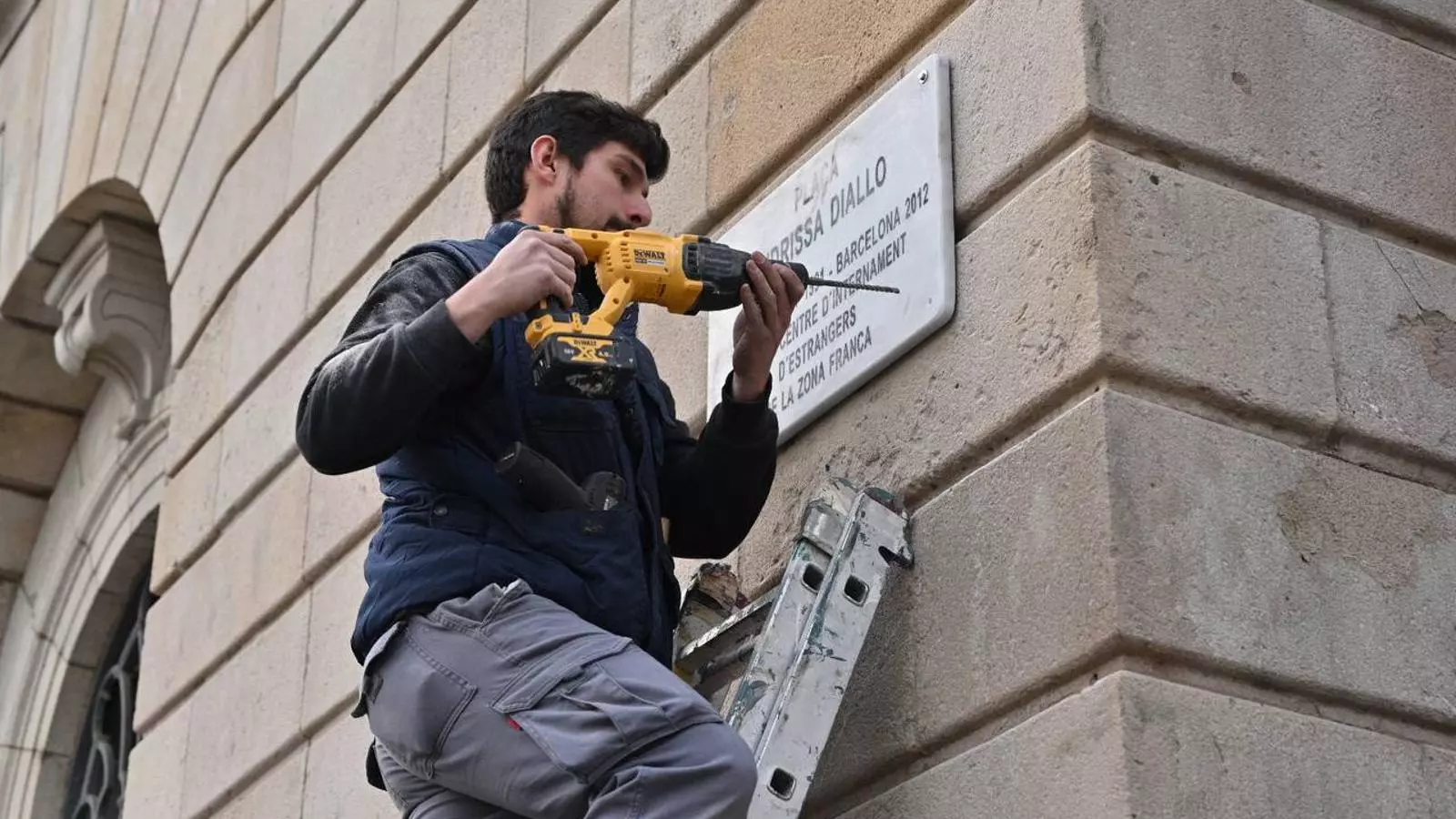 El moment en què els operaris han col·locat la nova placa