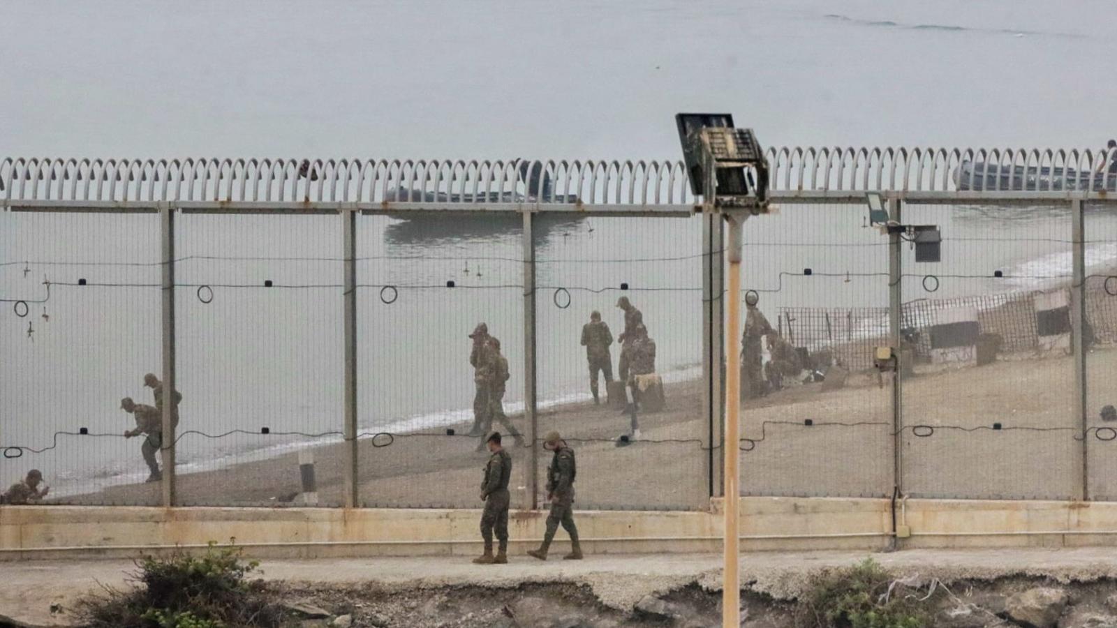 Spanish and Moroccan soldiers at the Tarajal breakwater that separates Ceuta from Morocco.