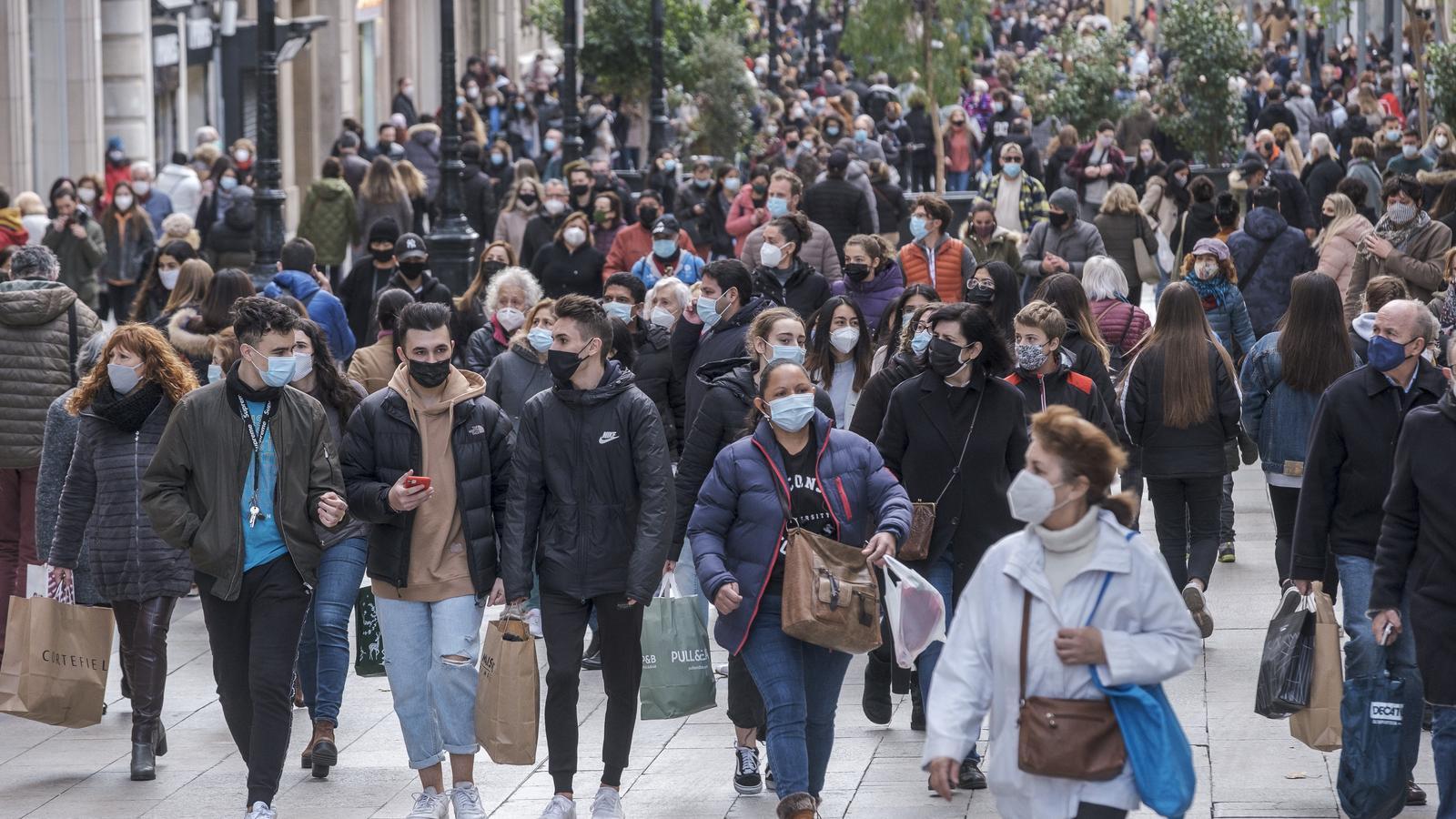 People wearing masks walk through downtown Barcelona, almost a year after the outbreak of the pandemic.