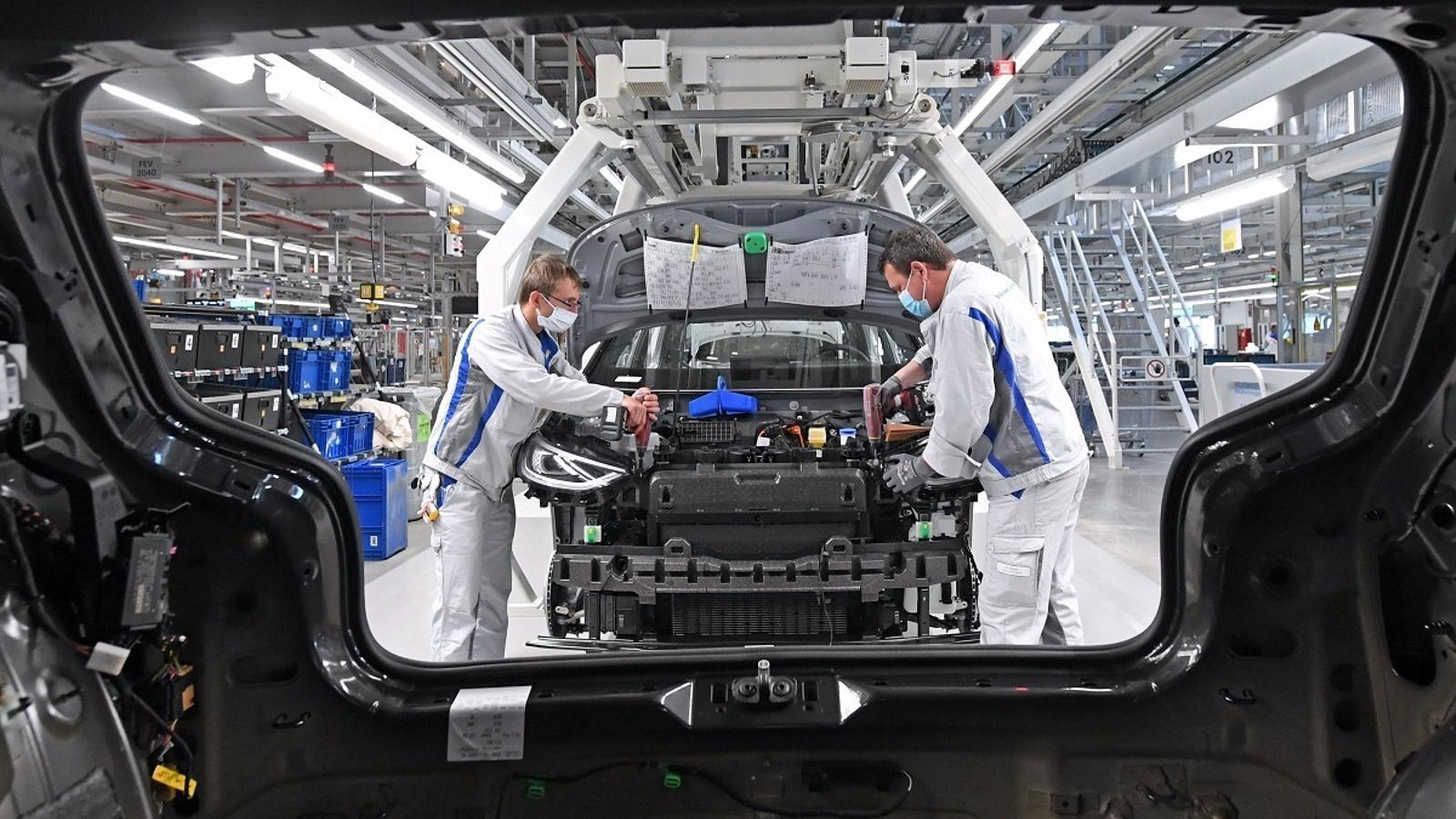 Unos trabajadores montando la parte inferior de un coche eléctrico en la cadena de montaje de la fábrica de Volkswagen en Zwickau, Alemania, en una imagen de archivo.