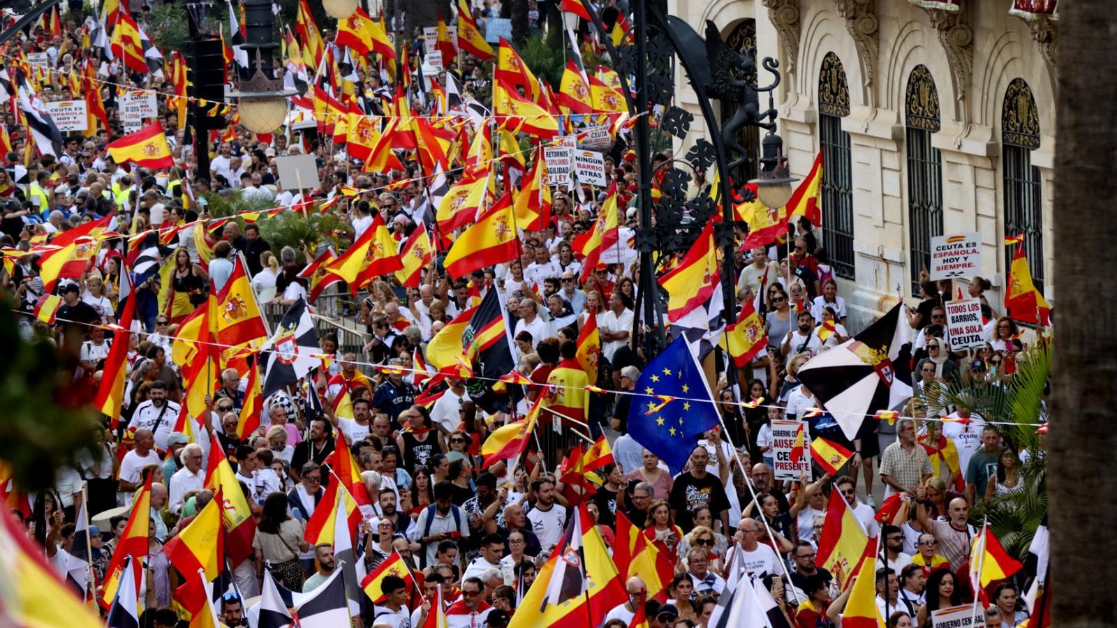 Manifestantes con banderas españolas llenan las calles de Ceuta en contra de la gestión de la crisis migratoria.