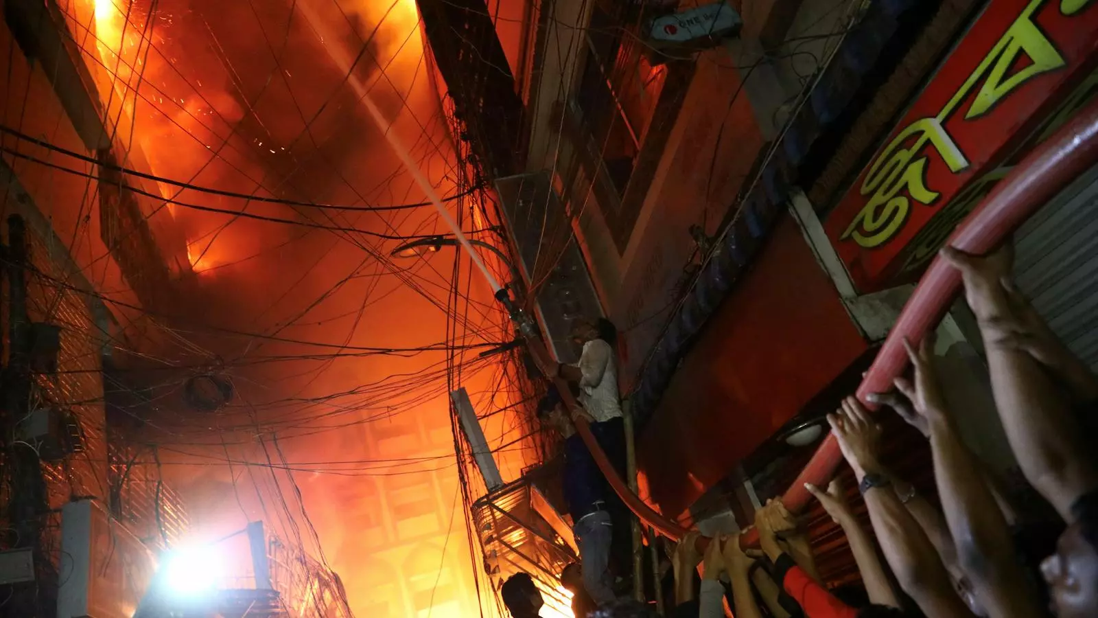 Voluntaris i bombers intentant apagar les flames que es propaguen ràpidament per edificis de Dacca, la capital de Bangladesh