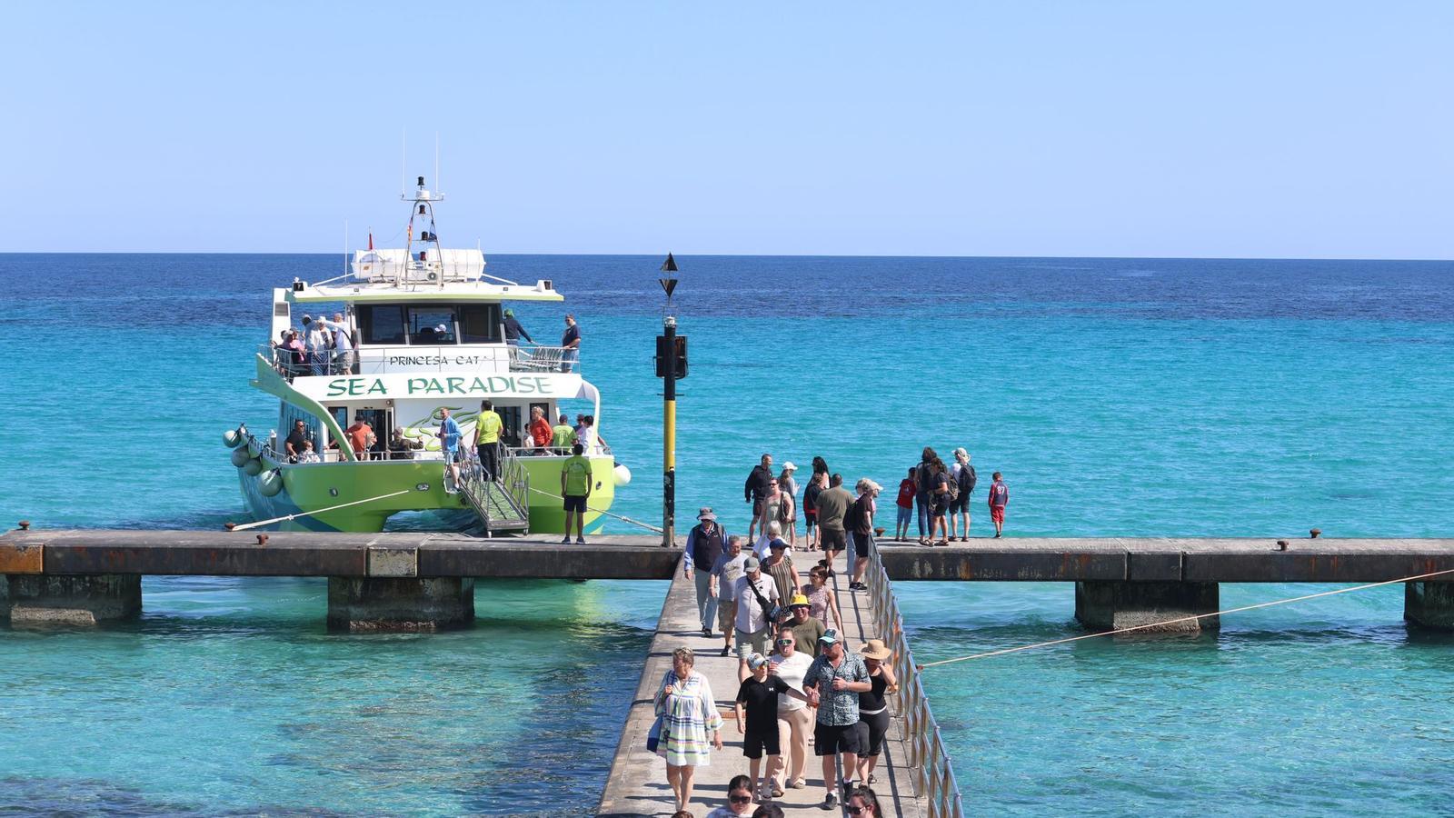 Turistes pugen per l'embarcador de la discòrdia, a Cala Millor, aquest dimarts