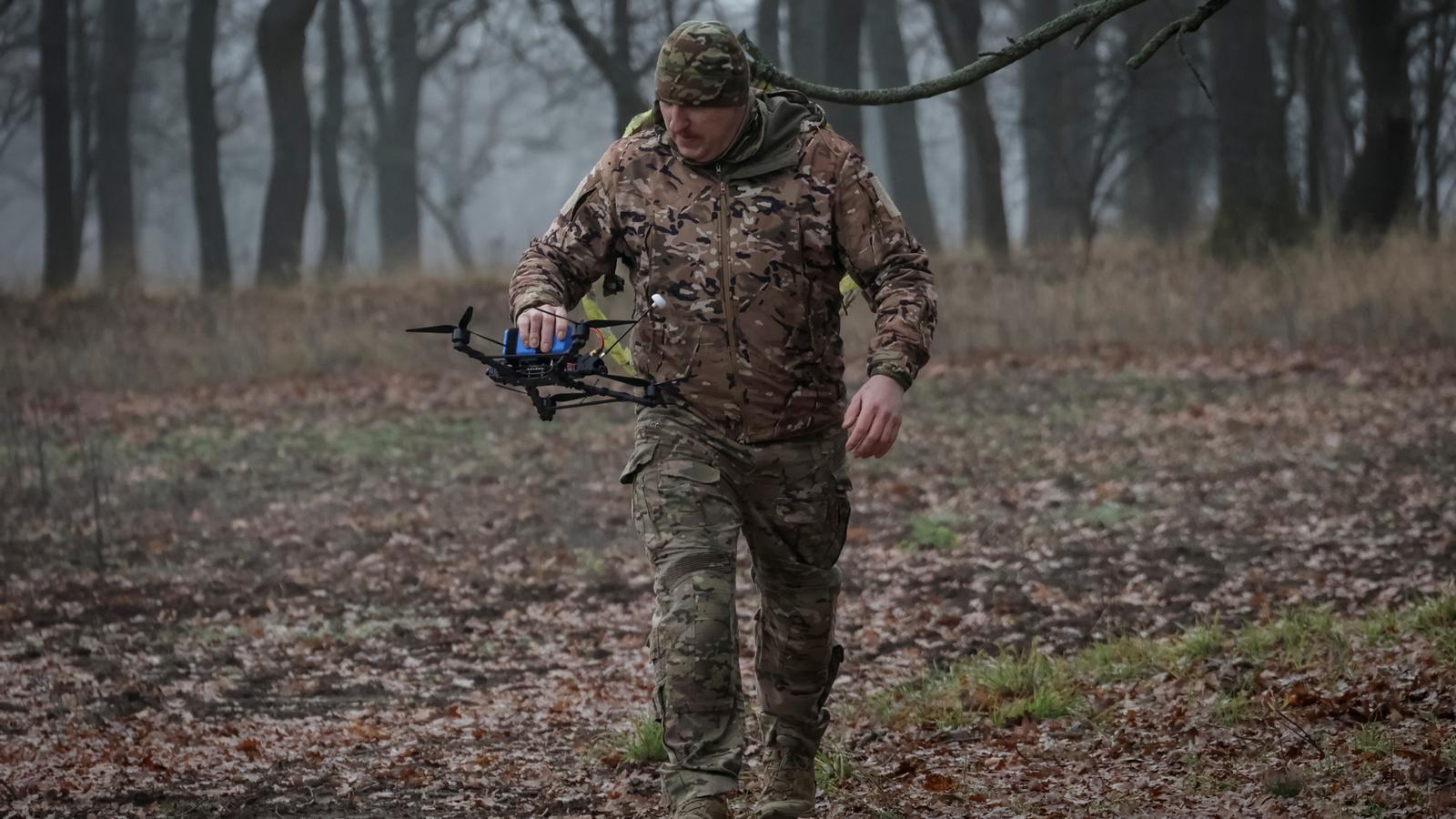 Un soldado ucraniano transporta un dron en la región de Járkov, Ucrania.