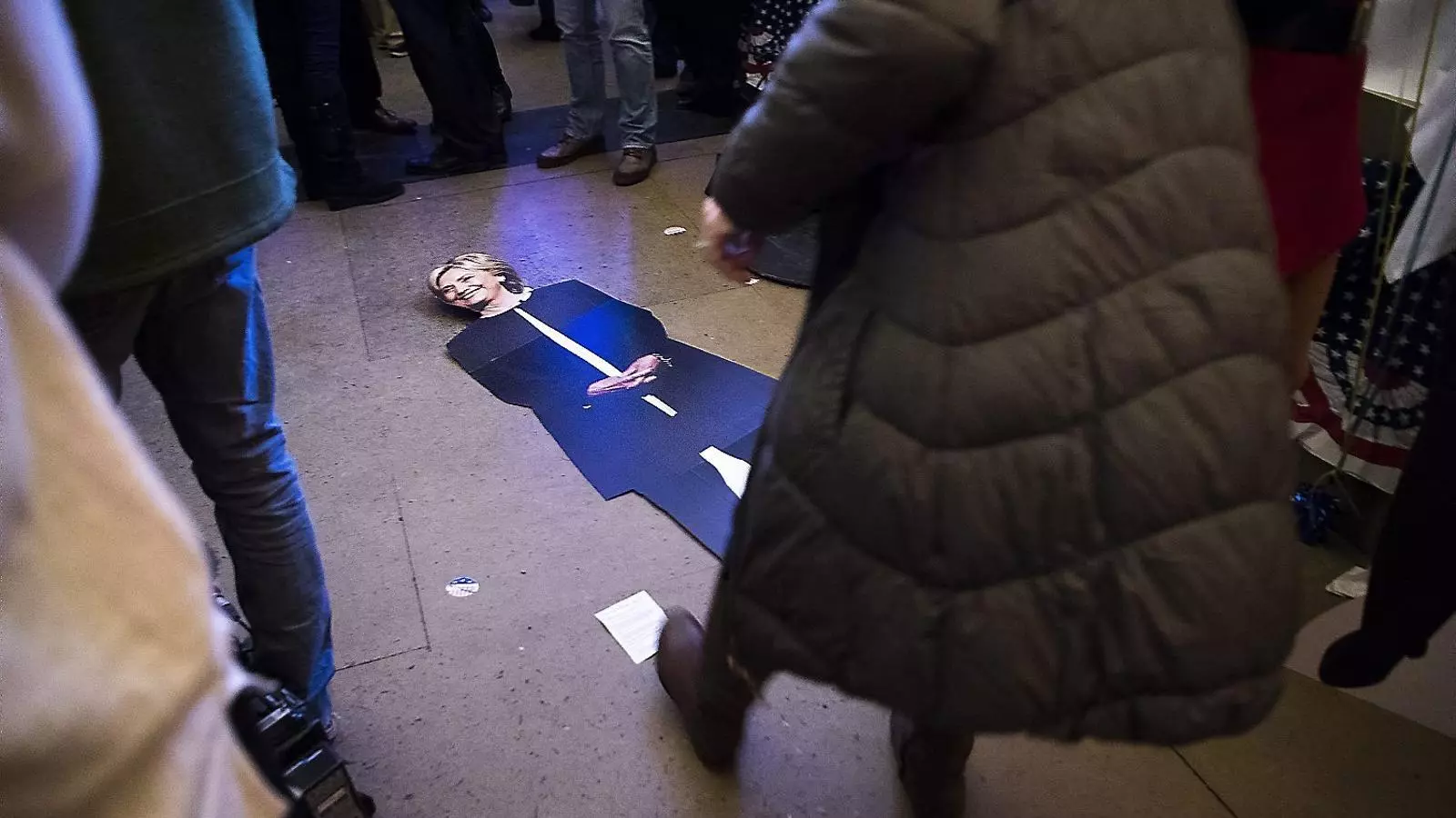 Una dona evita trepitjar el retrat caigut a terra de la candidata demòcrata, Hillary Clinton, en una festa electoral a Berna (Suïssa) organitzada per l’ambaixada dels EUA.