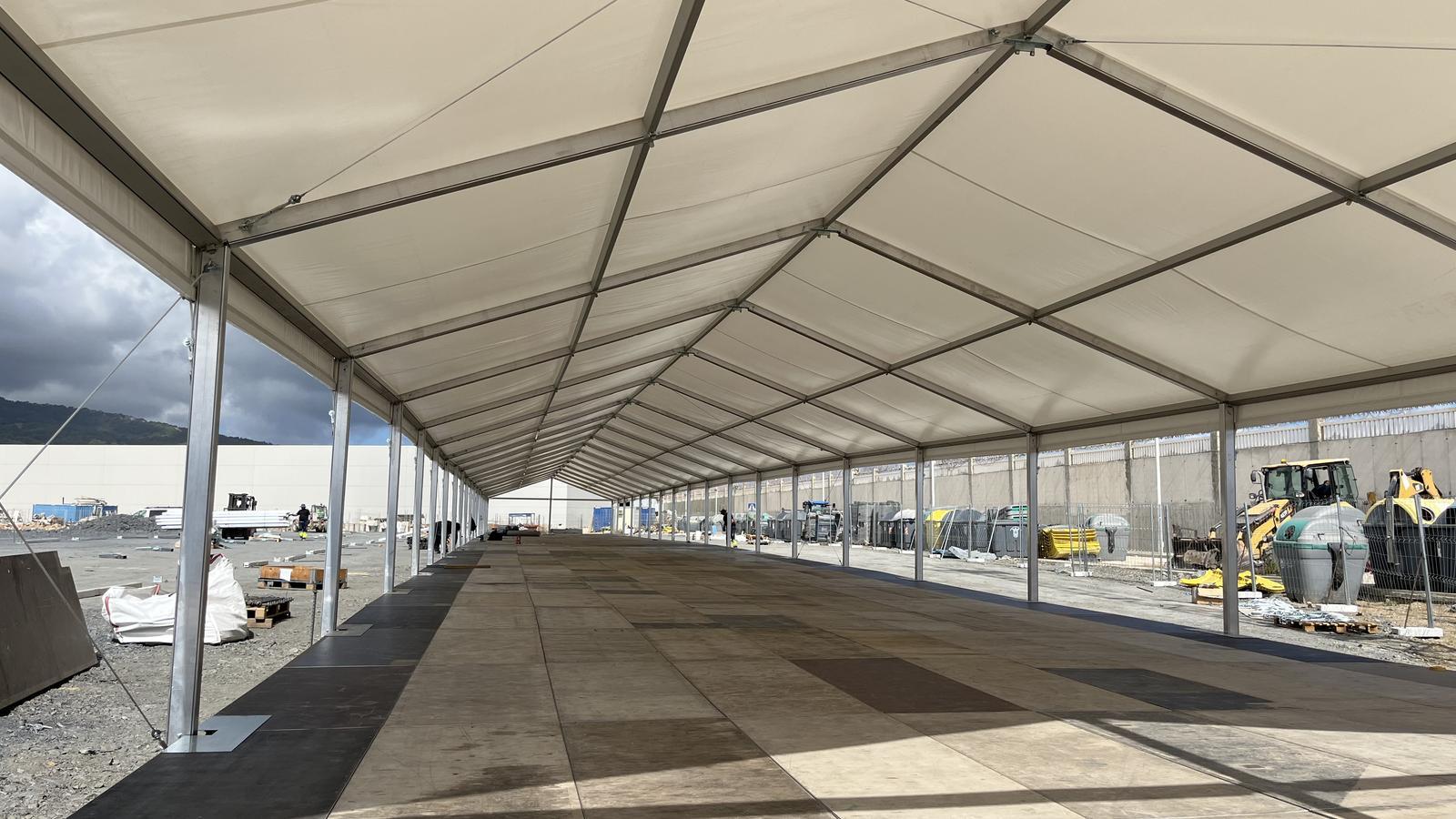 Workers are working on the assembly of a large tent at the Poniente dock of the port of Ceuta to accommodate up to a thousand migrants.