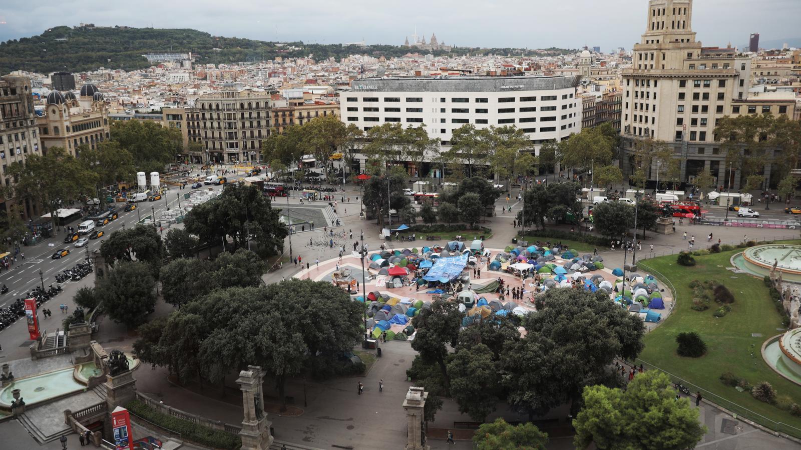 Acampada en la plaza de Cataluña, en Barcelona, mientras se debate y vota los decretos de vivienda del Gobierno celebrado este viernes en el Congreso de los Diputados en Madrid.