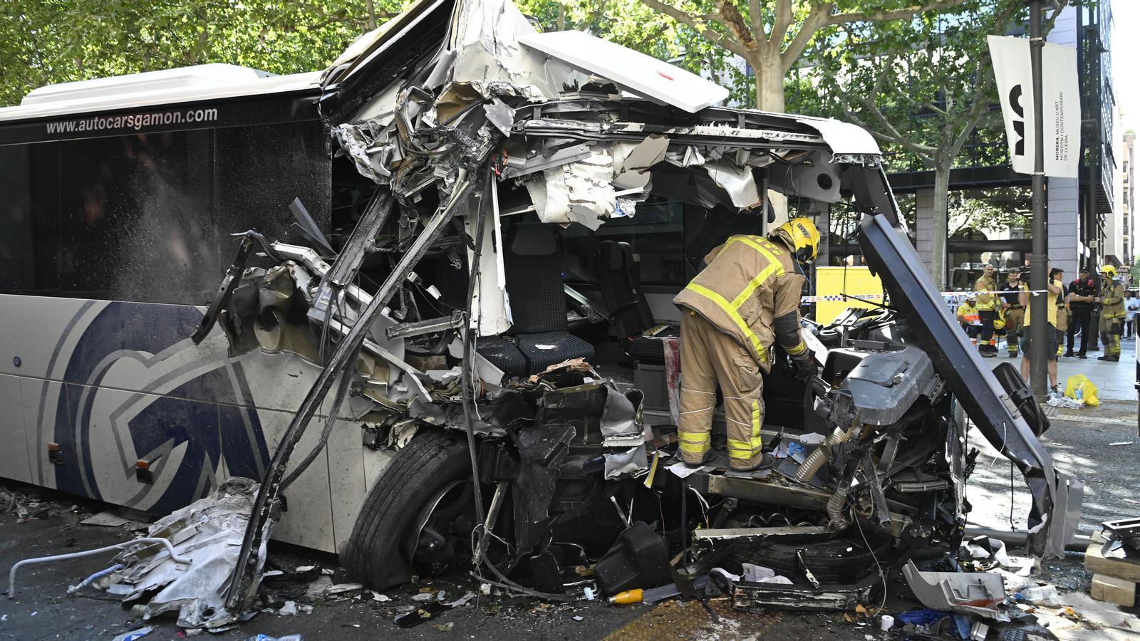 Un bombero trabaja en los restos del autocar siniestrado en Lérida