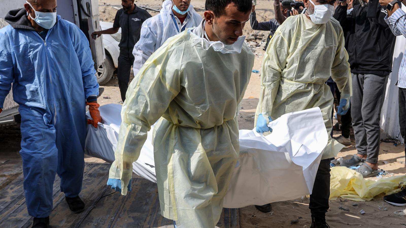 Quatre sanitaris transporten un dels cadàvers que Israel ha entregat aquest dilluns a Khan Yunis, al sud de la Franja de Gaza