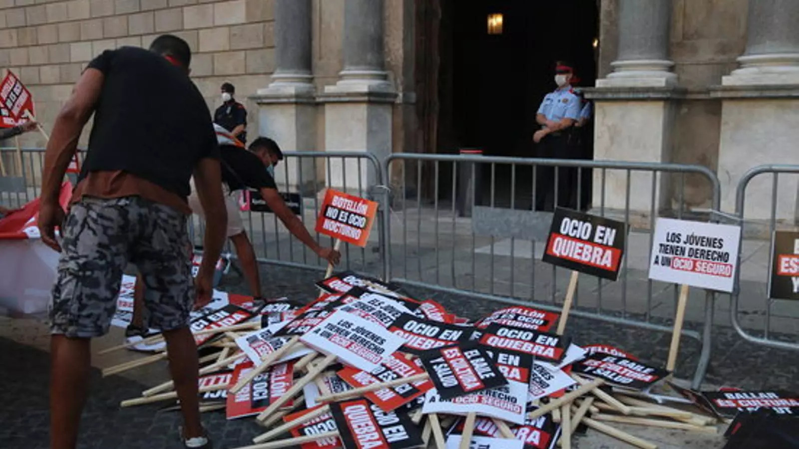 Dos treballadors de l'oci nocturn deixant les seves pancartes de protesta davant el Palau de la Generalitat el 29 de juliol de 2020.