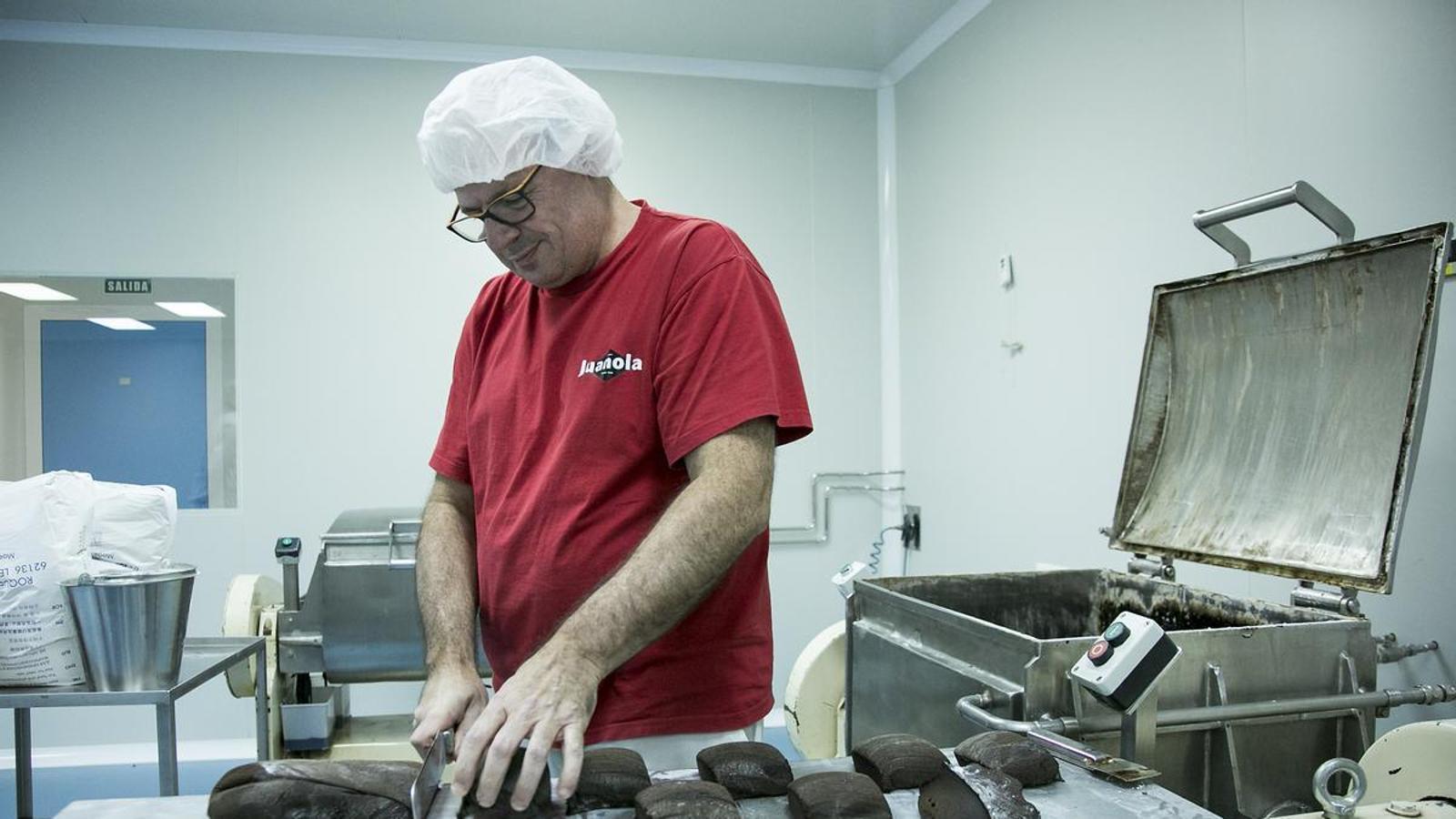 Empleados de la fábrica de pastillas Juanola trabajando la masa a base de regaliz que se utiliza para elaborar el producto final.