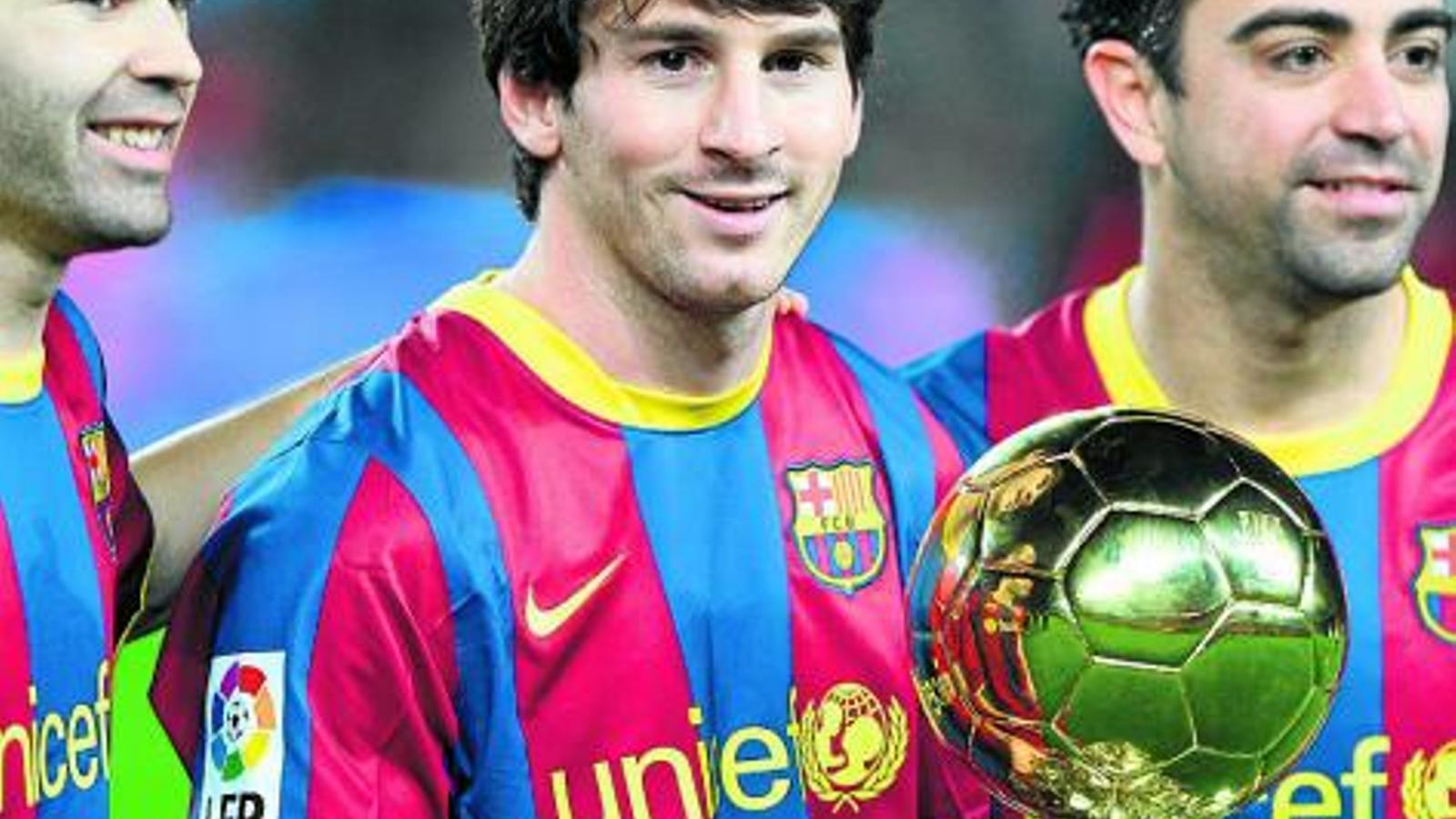 Messi presentant la Pilota d'Or al Camp Nou amb Iniesta i Xavi.