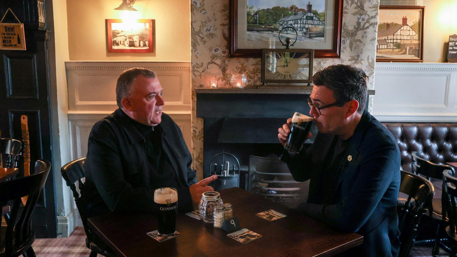 British Prime Minister, Andy Burnham, on the right, speaks with a pub owner on June 5, during the electoral campaign in the district of Makerfield, in northern England, which led him to return to the Commons and, eventually, to 10 Downing Street.