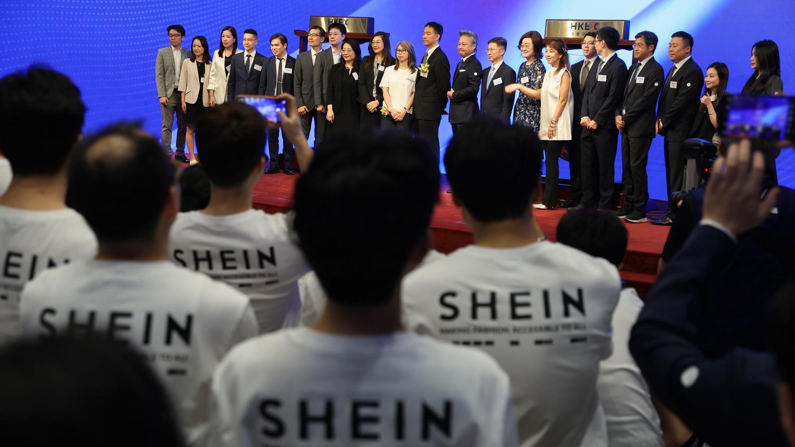 Executives and employees of the company SHEIN pose during its debut on the stock market in Hong Kong.