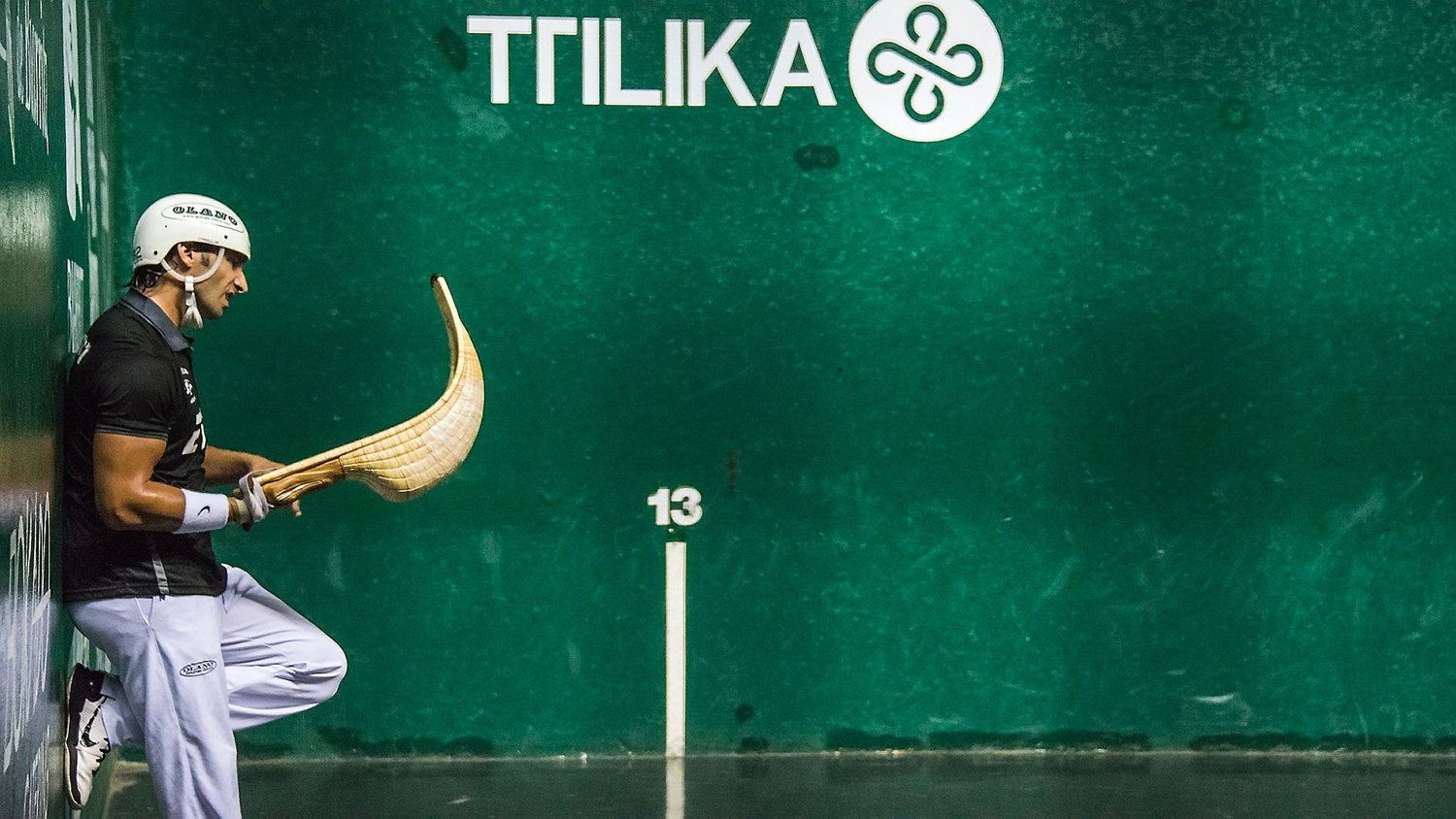 A Jai Alai player resting during a match.