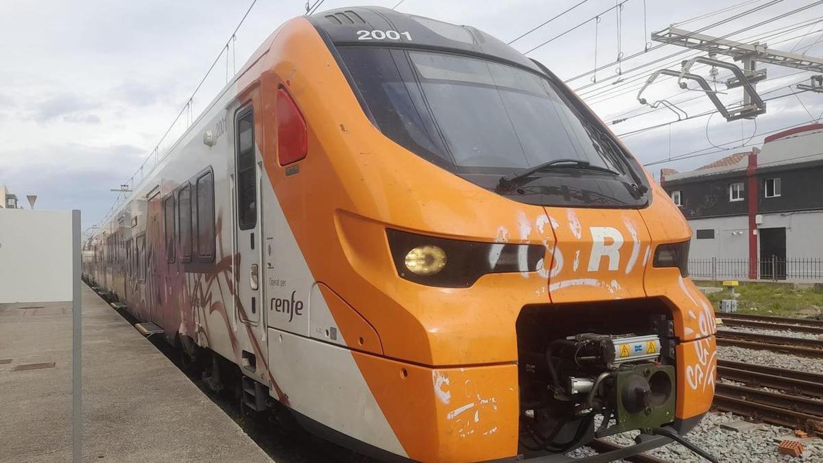 Image of one of Alstom's new trains for Rodalies circulating in tests, stopped on an Adif track and covered in graffiti