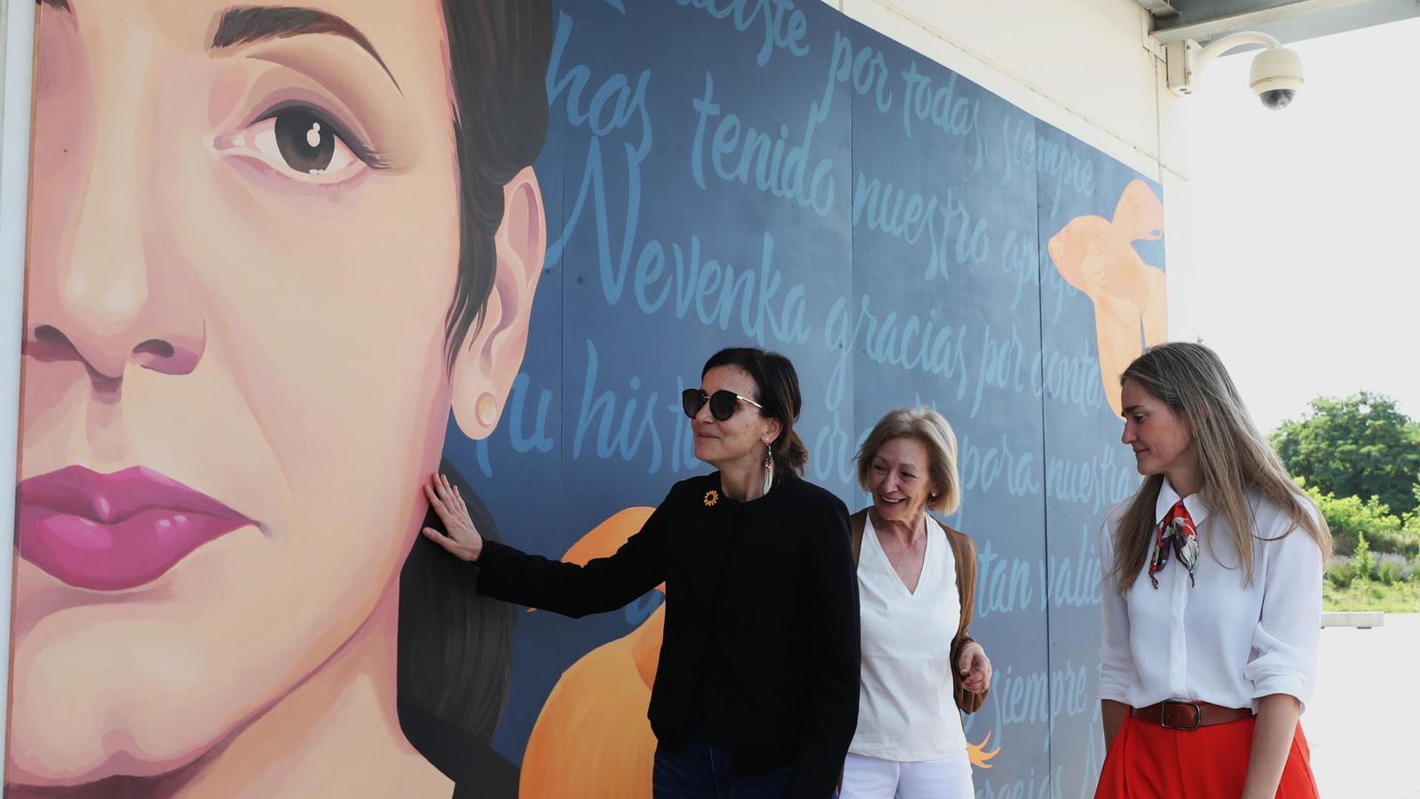 Nevenka Fernández tocando emocionada un mural con su cara pintada.