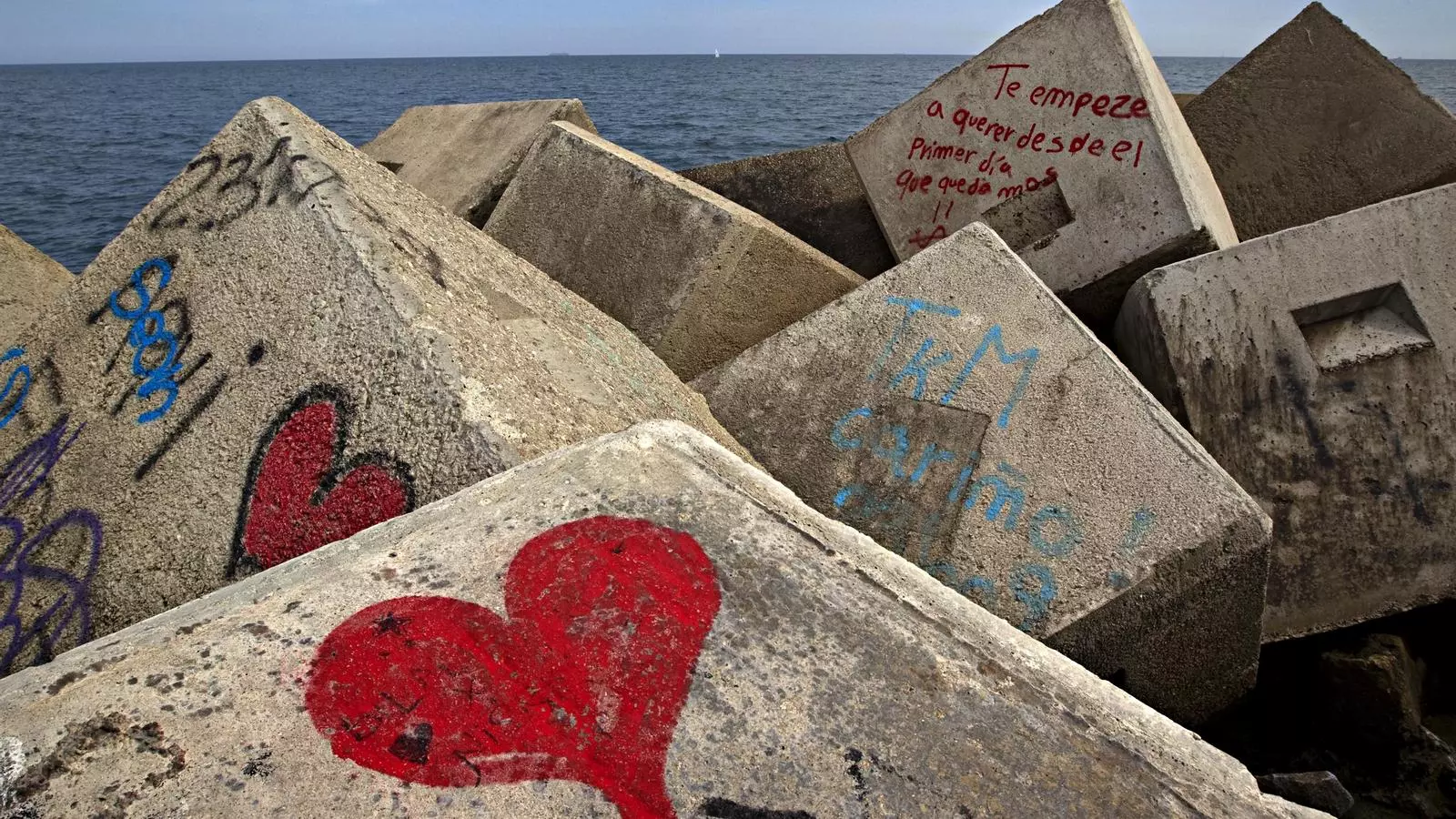 Blocs de pedra amb pintades romàntiques a la platja de Barcelona.