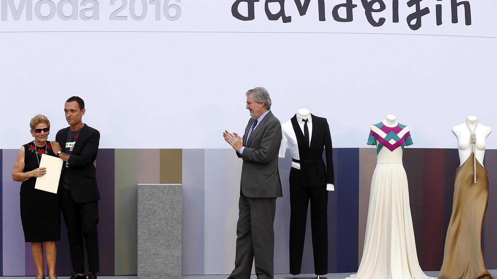 La mare de Delfín va rebre el premi de mans de Méndez de Vigo, acompanyada de Gorka Postigo i al costat de tres vestits del creador.