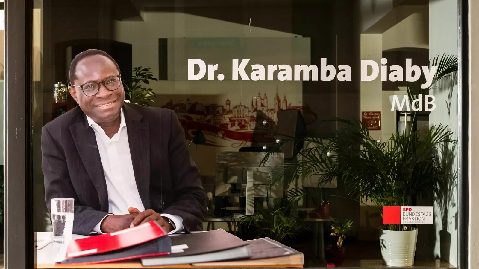 L'oficina de Karamba Diaby, amb els forats al vidre.
