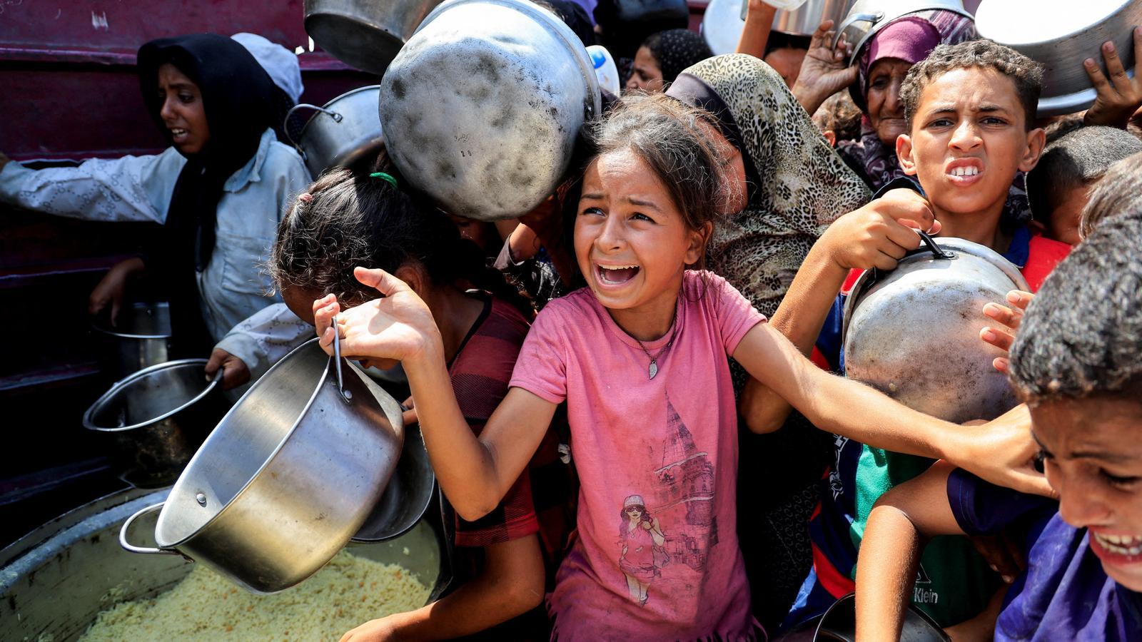 Crying babies at a food collection point in Gaza.