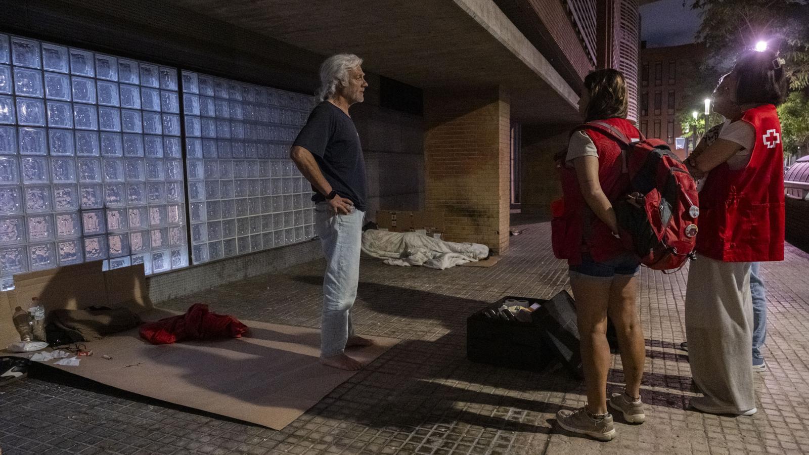 Manuel Heredia speaking with the Red Cross volunteers who attend him on the street where he lives.