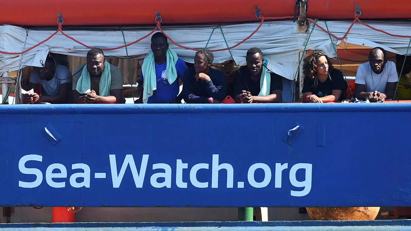 Passatgers del 'Sea Watch' descansant en la borda de l'embarcació alemanya a prop de l'illa de Lampedusa