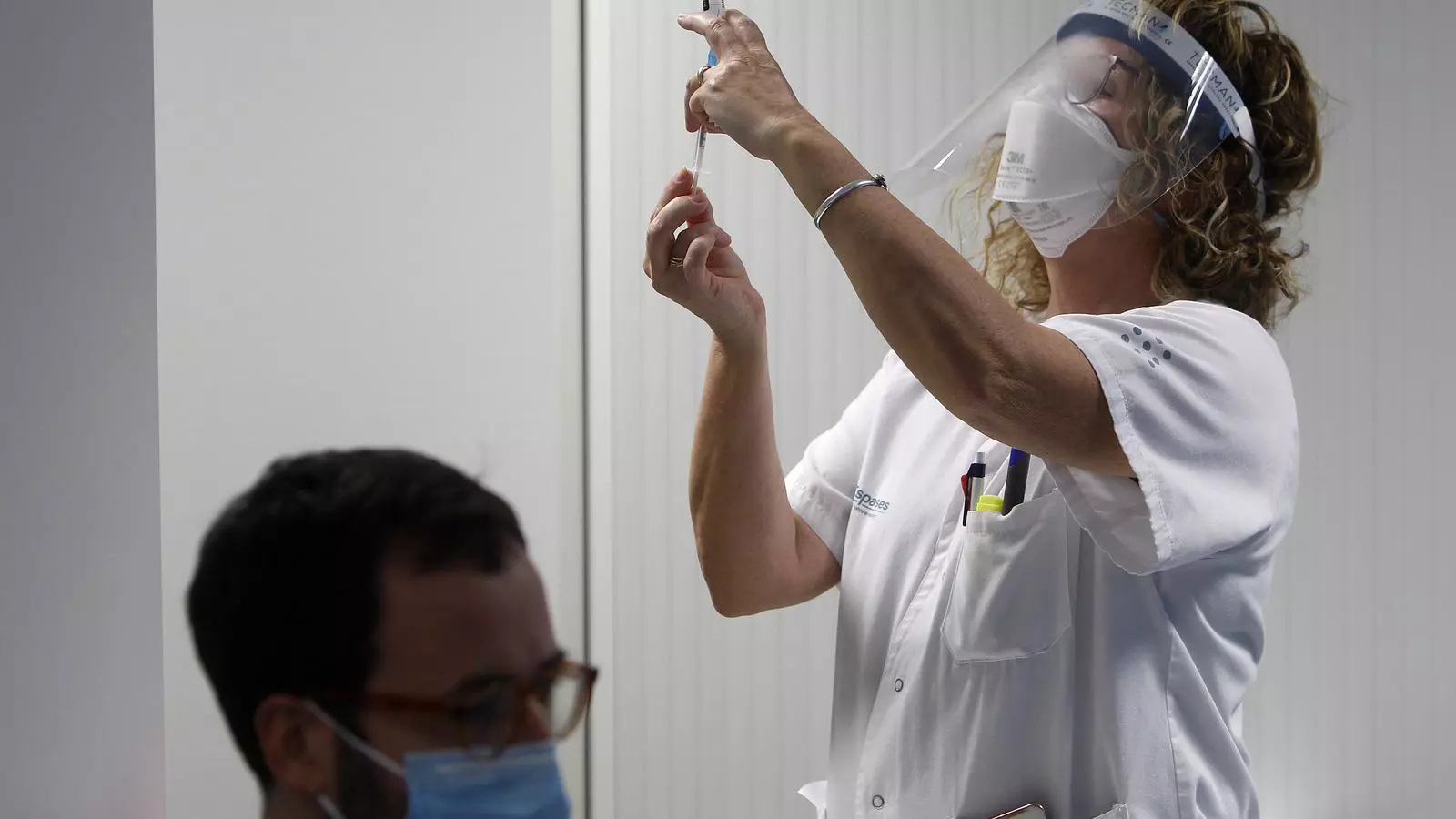 Una infermera vacunant contra el covid-19 a un treballador de Son Espases.