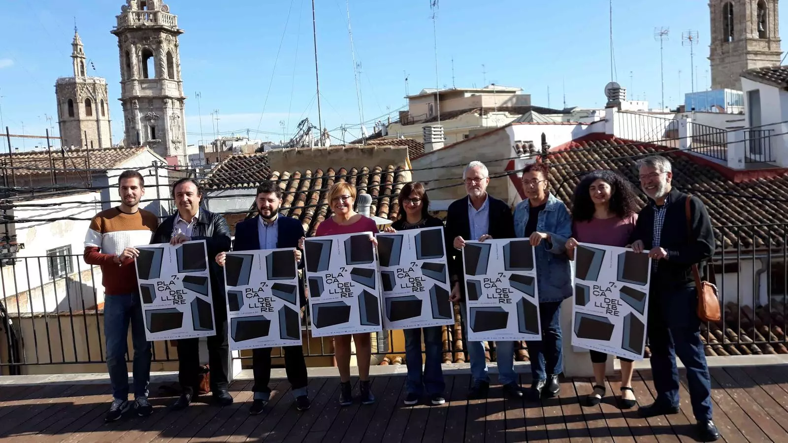 Representants de les entitats i administracions organitzadores de la Plaça del Llibre de València amb el cartell de la setena edició