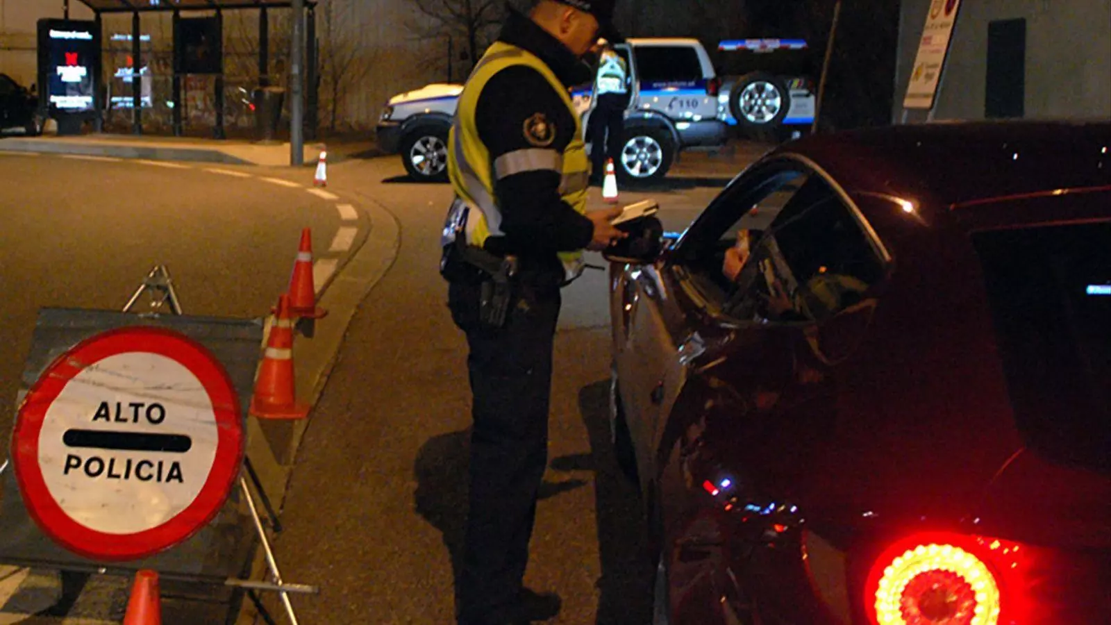 Un agent de policia realitzant un control d'alcoholèmia a un conductor.