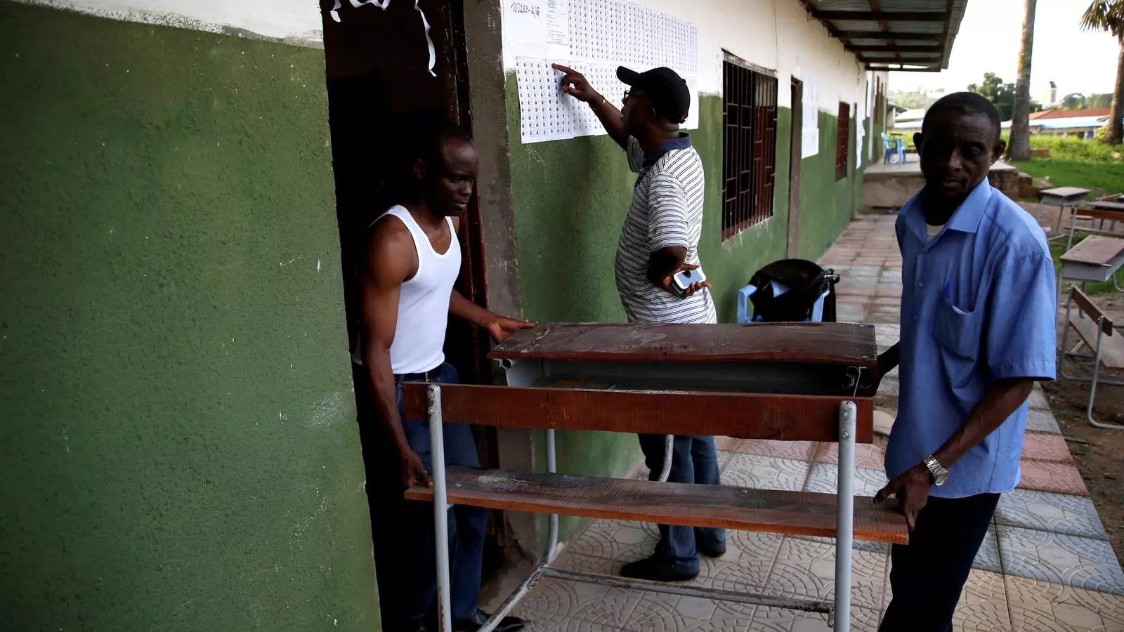 Treballadors preparant els últims detalls per a la jornada electoral congolesa, en un col·legi de Kinshasa