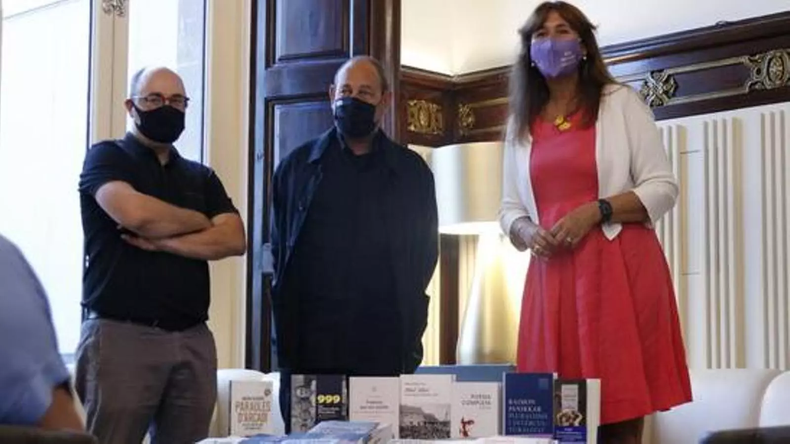 Els editors Miquel Adam i Joan Sala i la presidenta del Parlament, Laura Borràs durant l'entrega de llibres