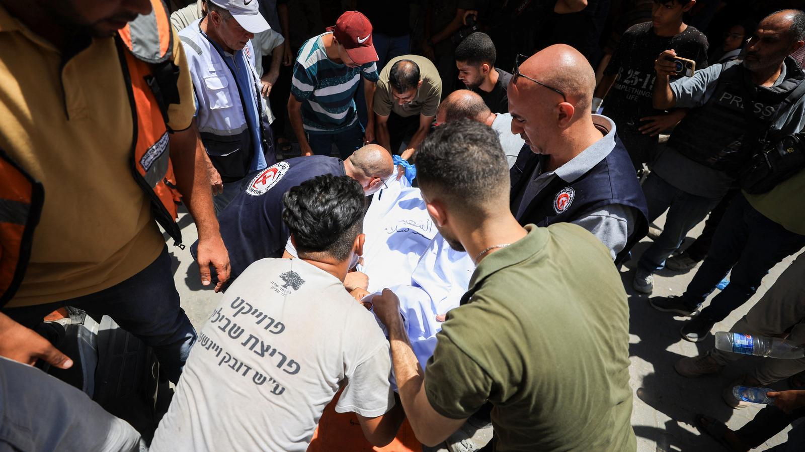 Palestinians carry the body of a Christian killed during the Israeli bombing of the Holy Family Church in Gaza.