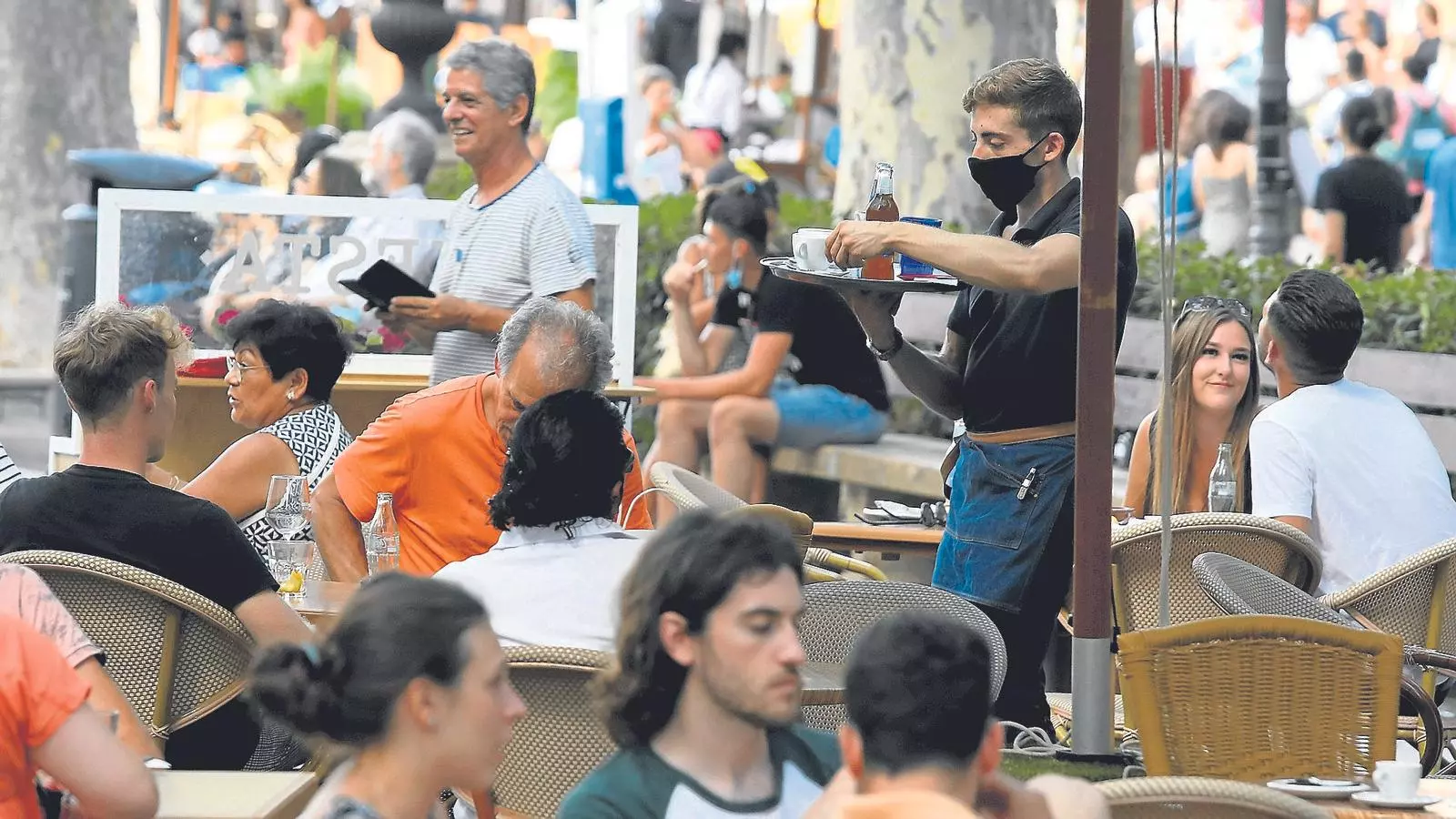 Un cambrer serveix els clients d'un cafè del centre de Palma.