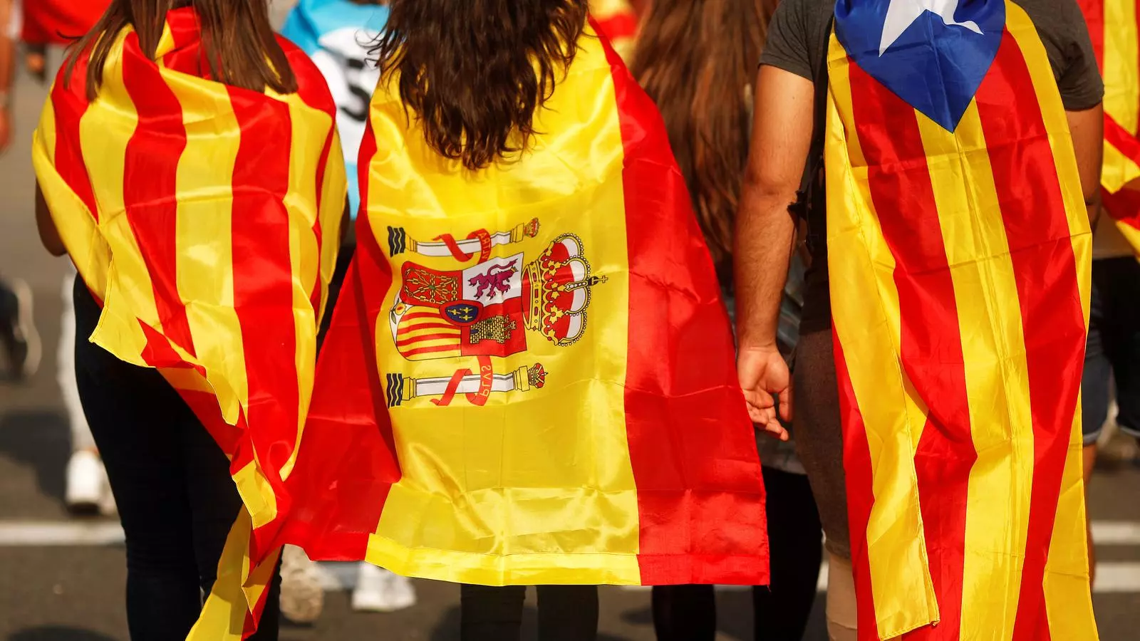 Tres joves vestits amb la bandera catalana, espanyola i l'estelada, a la manifestació contra la violència policial, el passat 3 d'octubre.