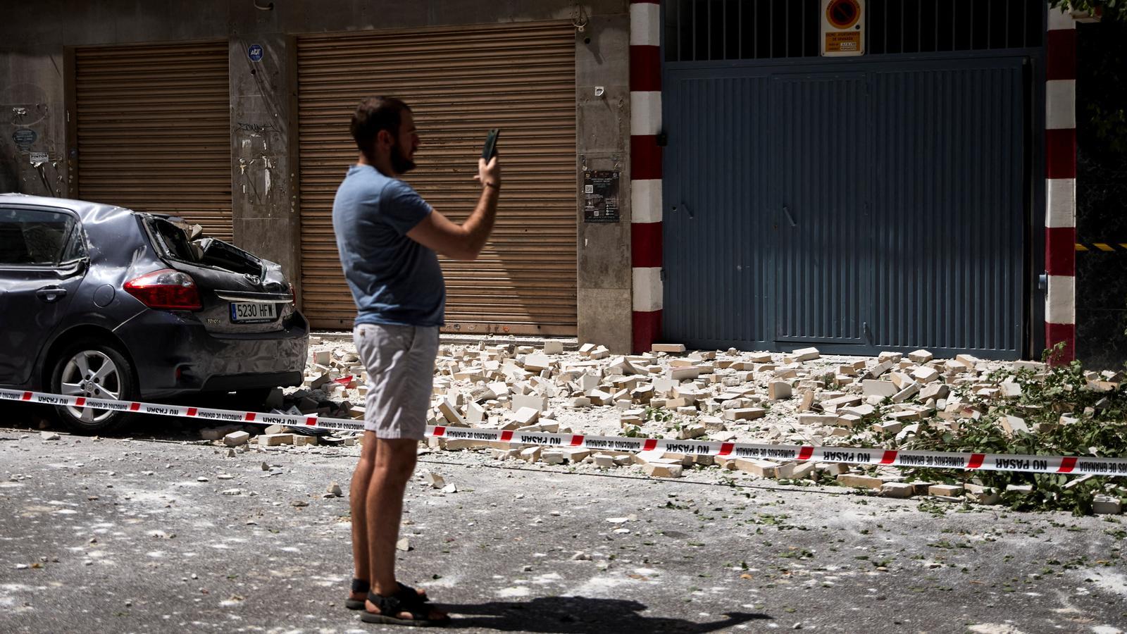 A man photographs the damage to a facade, after the 4.8 magnitude earthquake that shook Granada this Tuesday