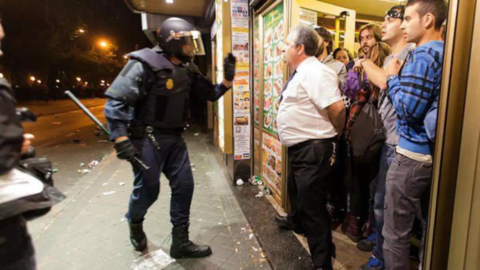 El cambrer de la cafeteria Prado de Madrid frena l'entrada d'un agent antidisturbis