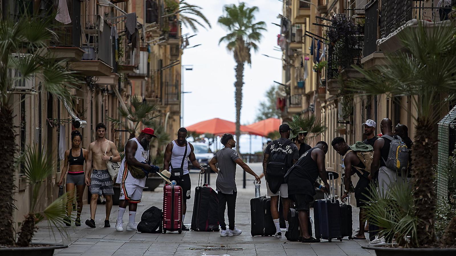 A group of tourists in front of a tourist apartment in the Barceloneta neighborhood.