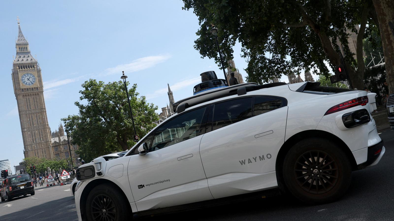 A Waymo autonomous vehicle drives near the Big Ben during tests for the future deployment of the driverless vehicle service.